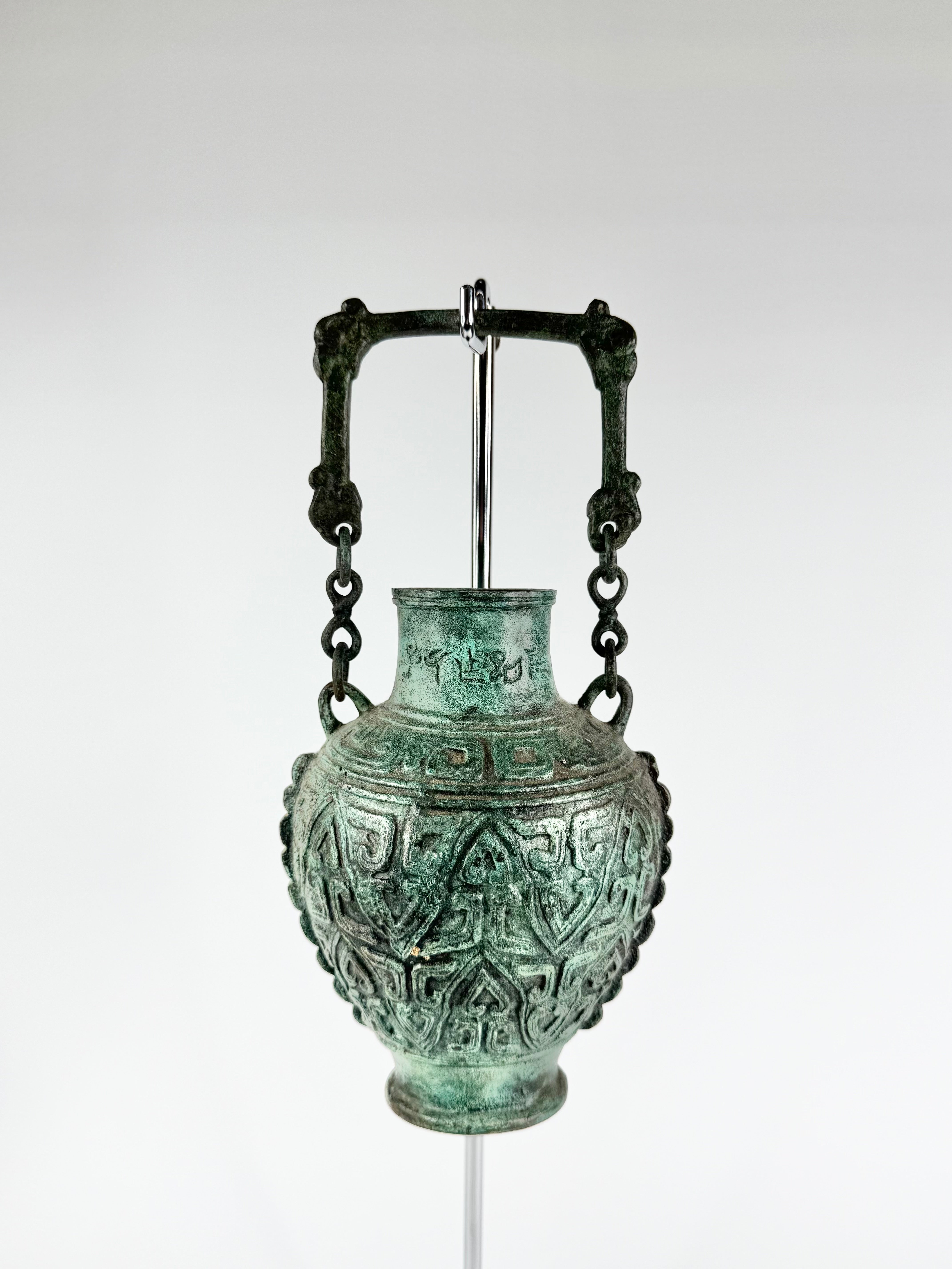 Bronze vase with intricate designs on a white background