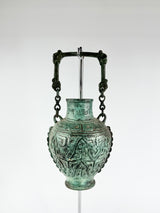 Bronze vase with intricate designs on a white background