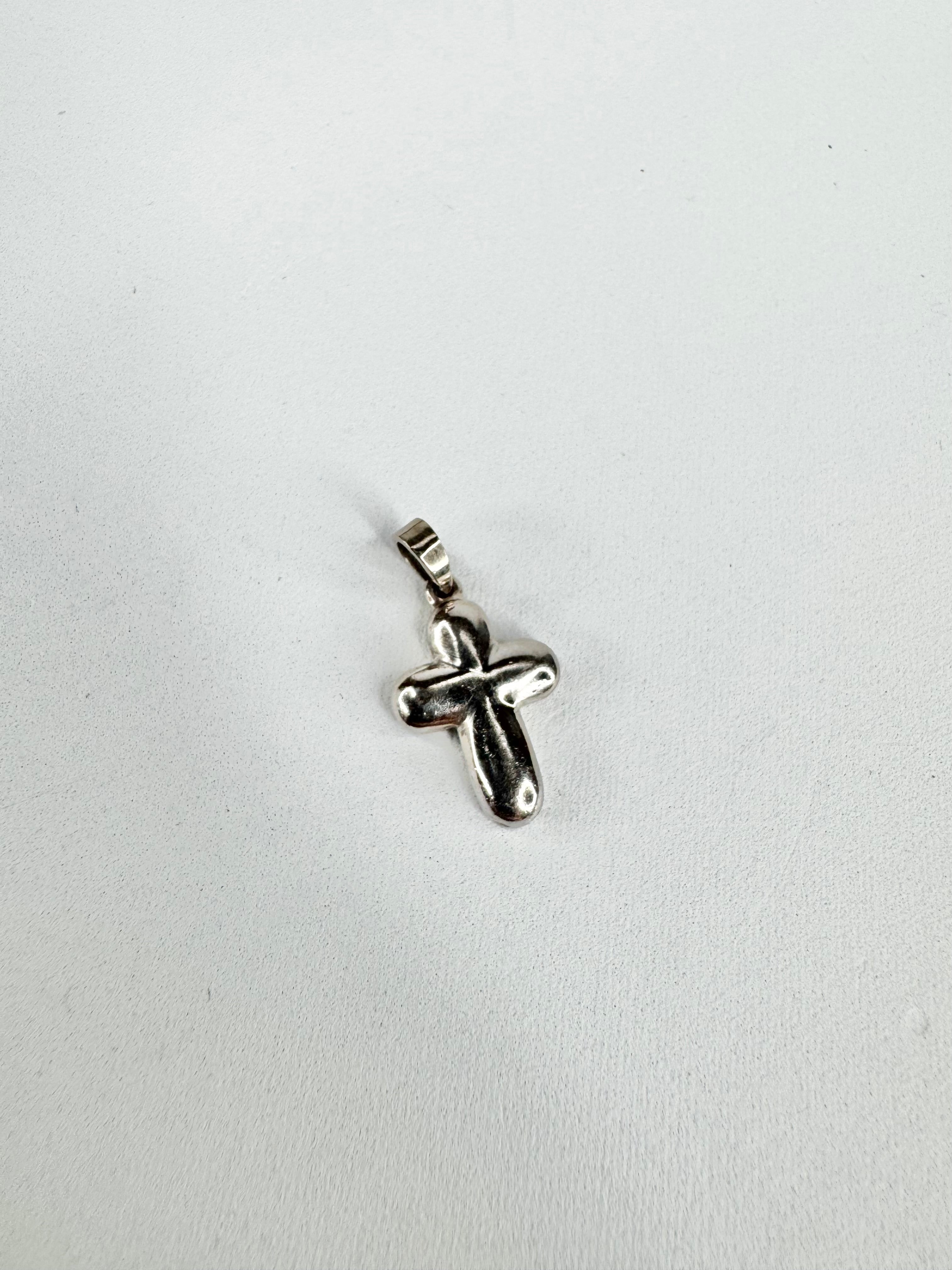 Silver cross pendant on a white background