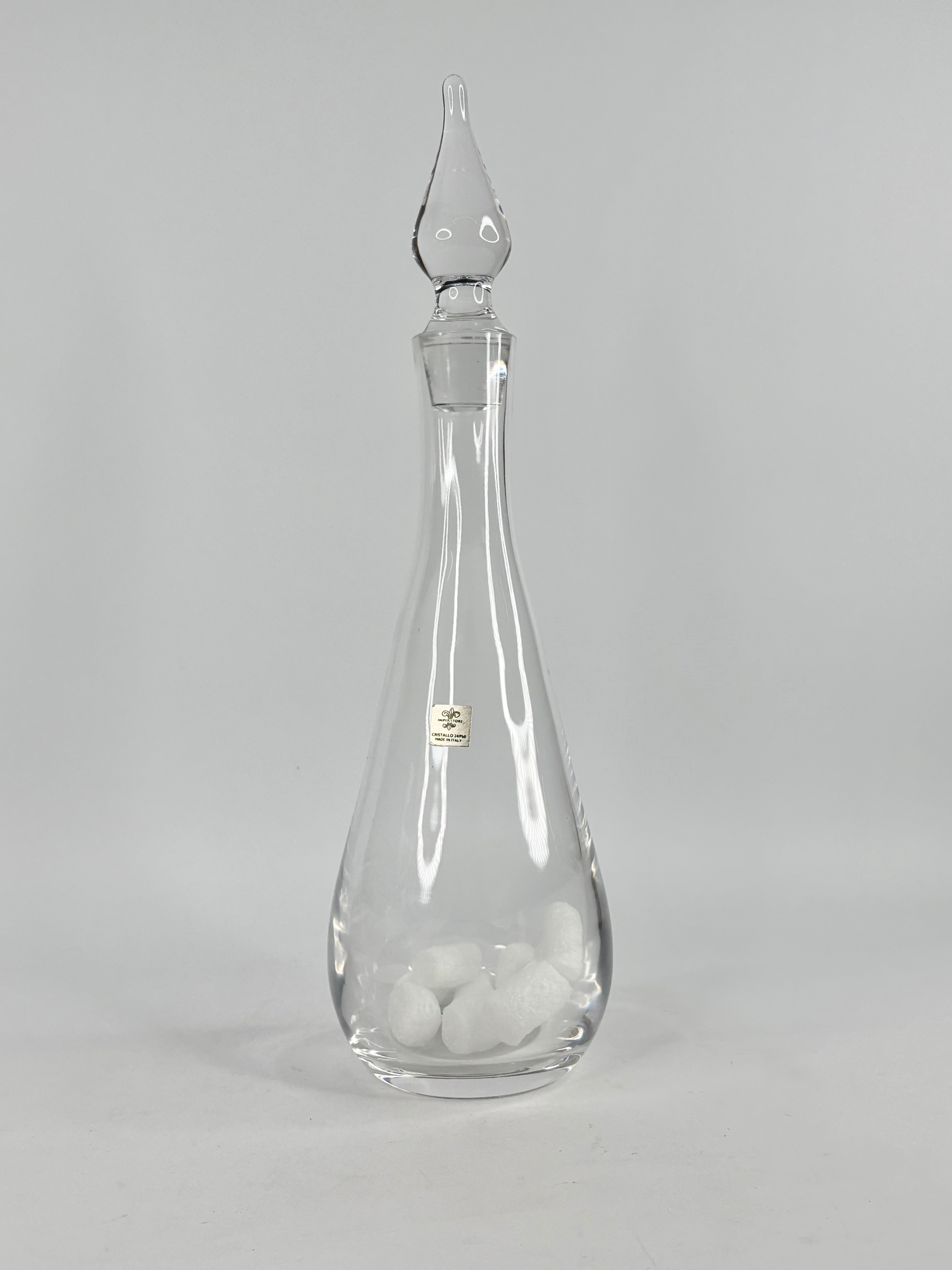 Clear glass decanter with stopper on a gray background