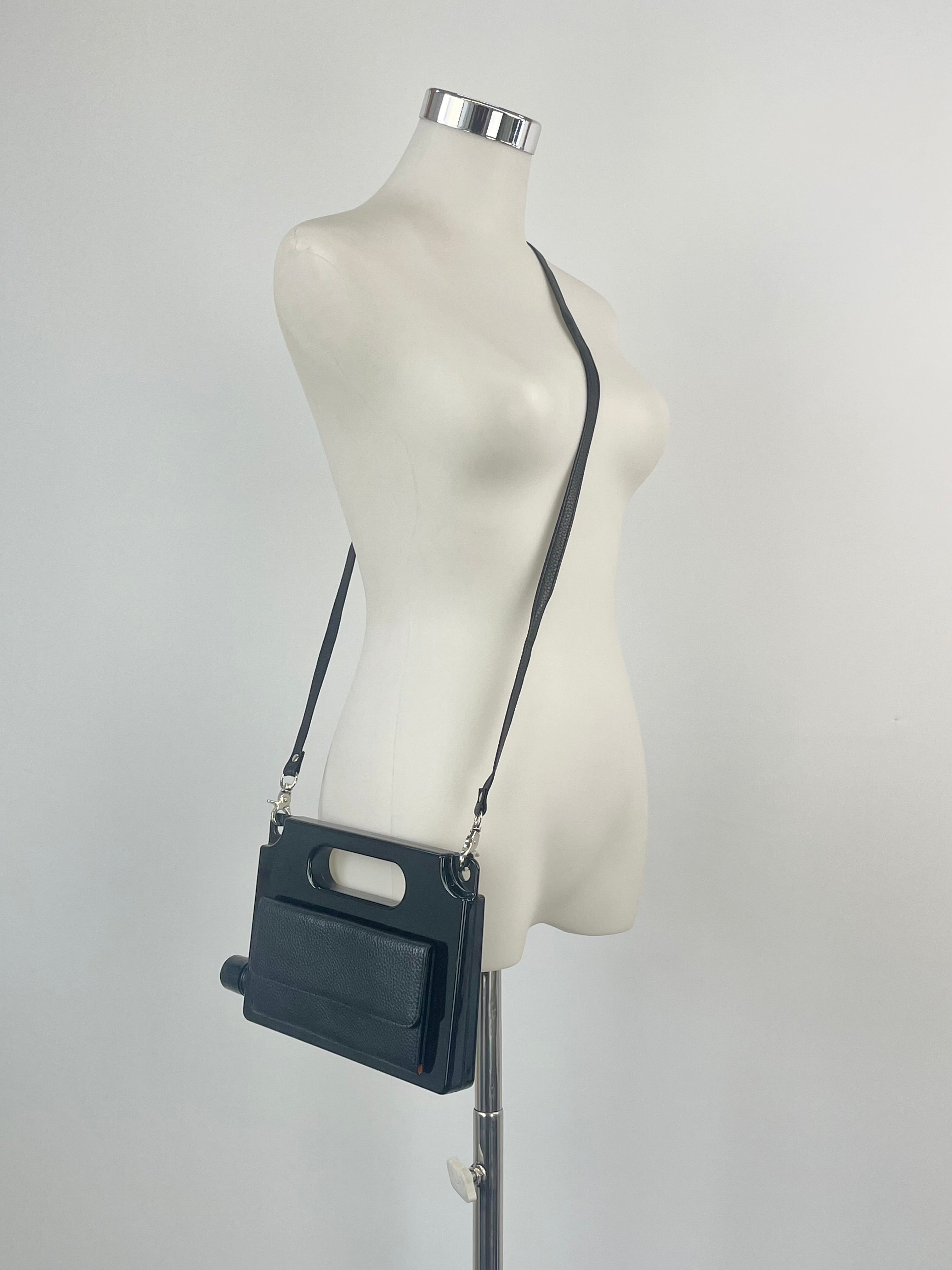 Black crossbody purse displayed on a mannequin