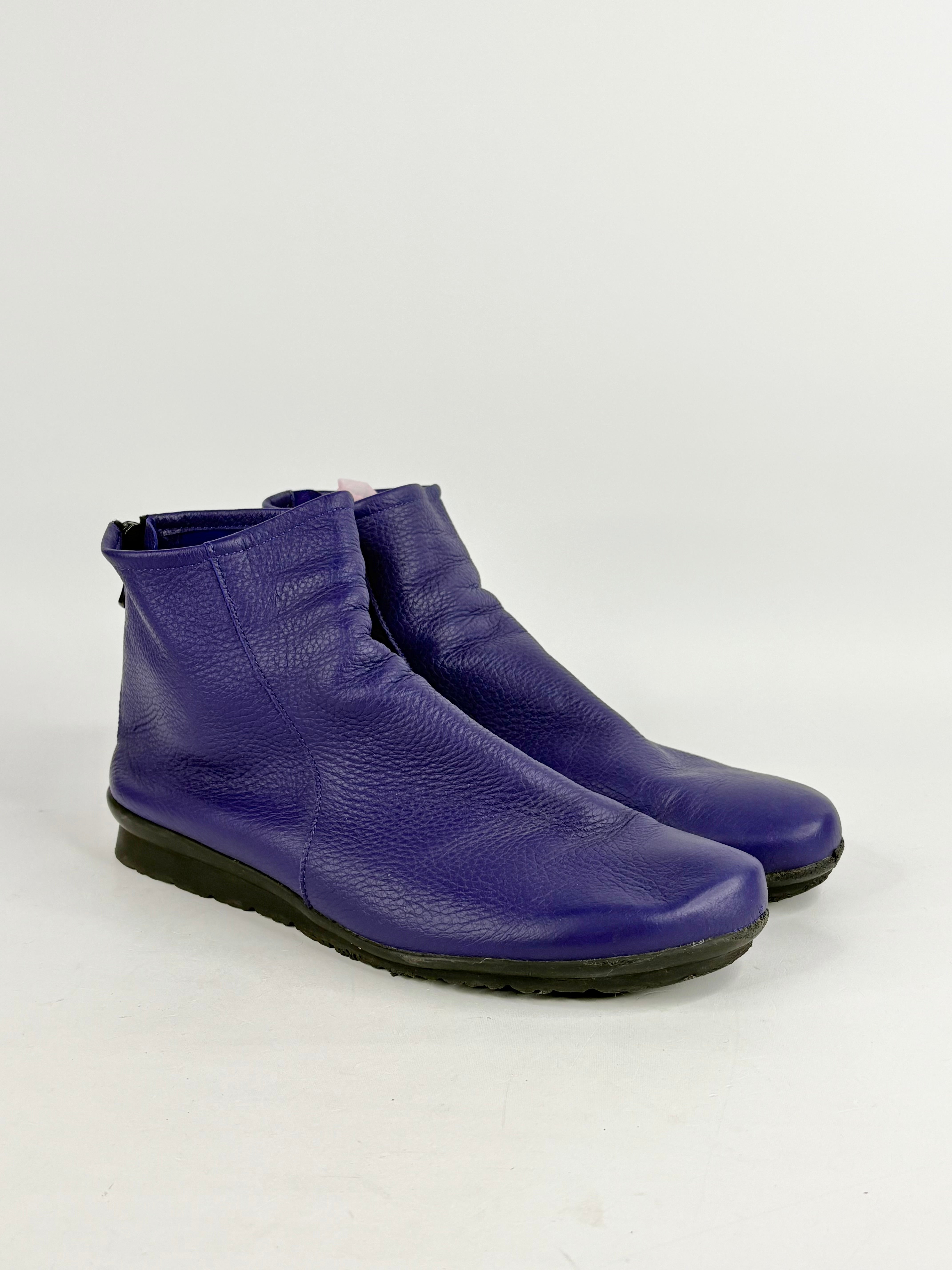 Pair of purple ankle boots on a white background