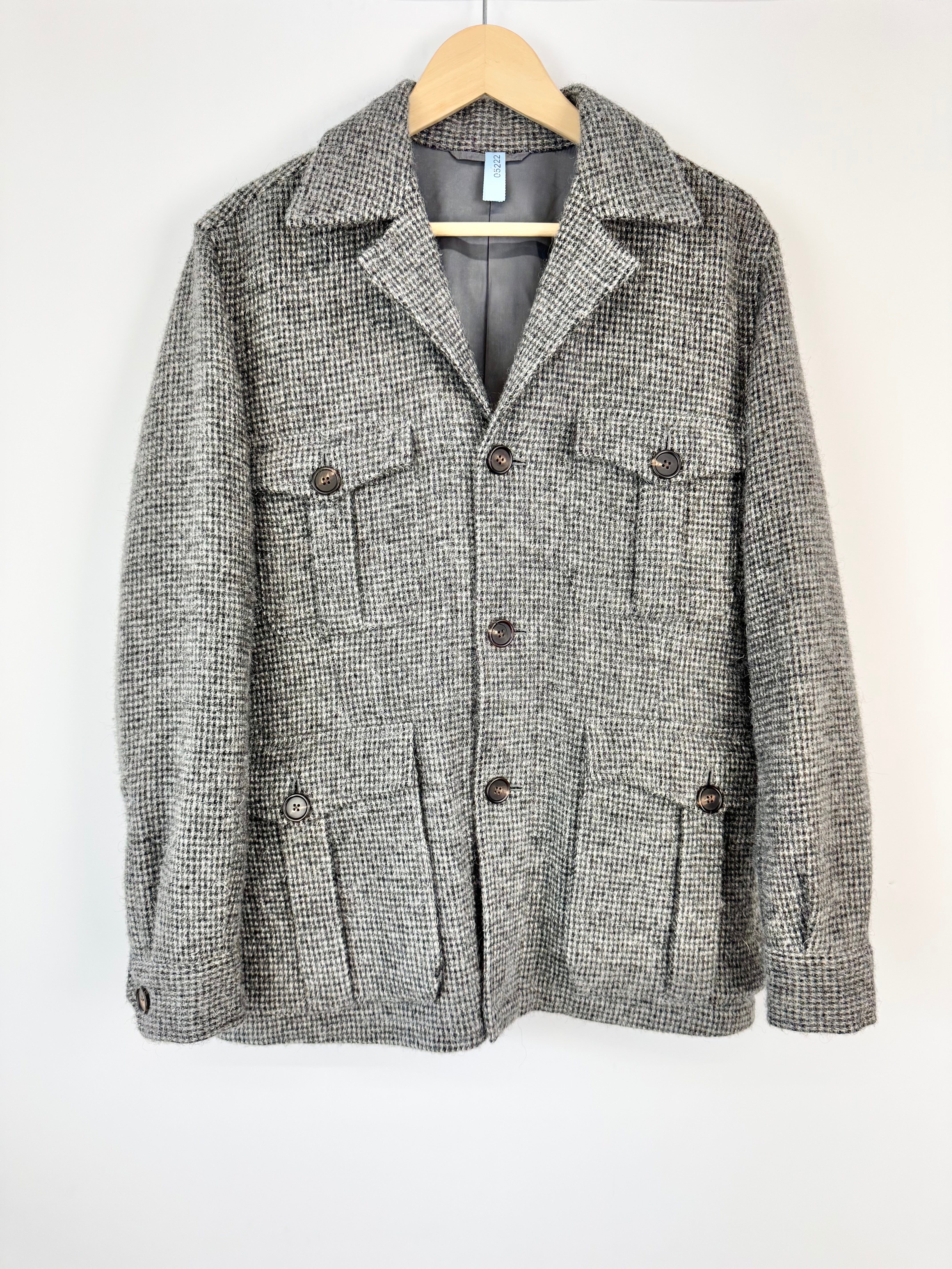 Gray checkered jacket on a hanger against a white background