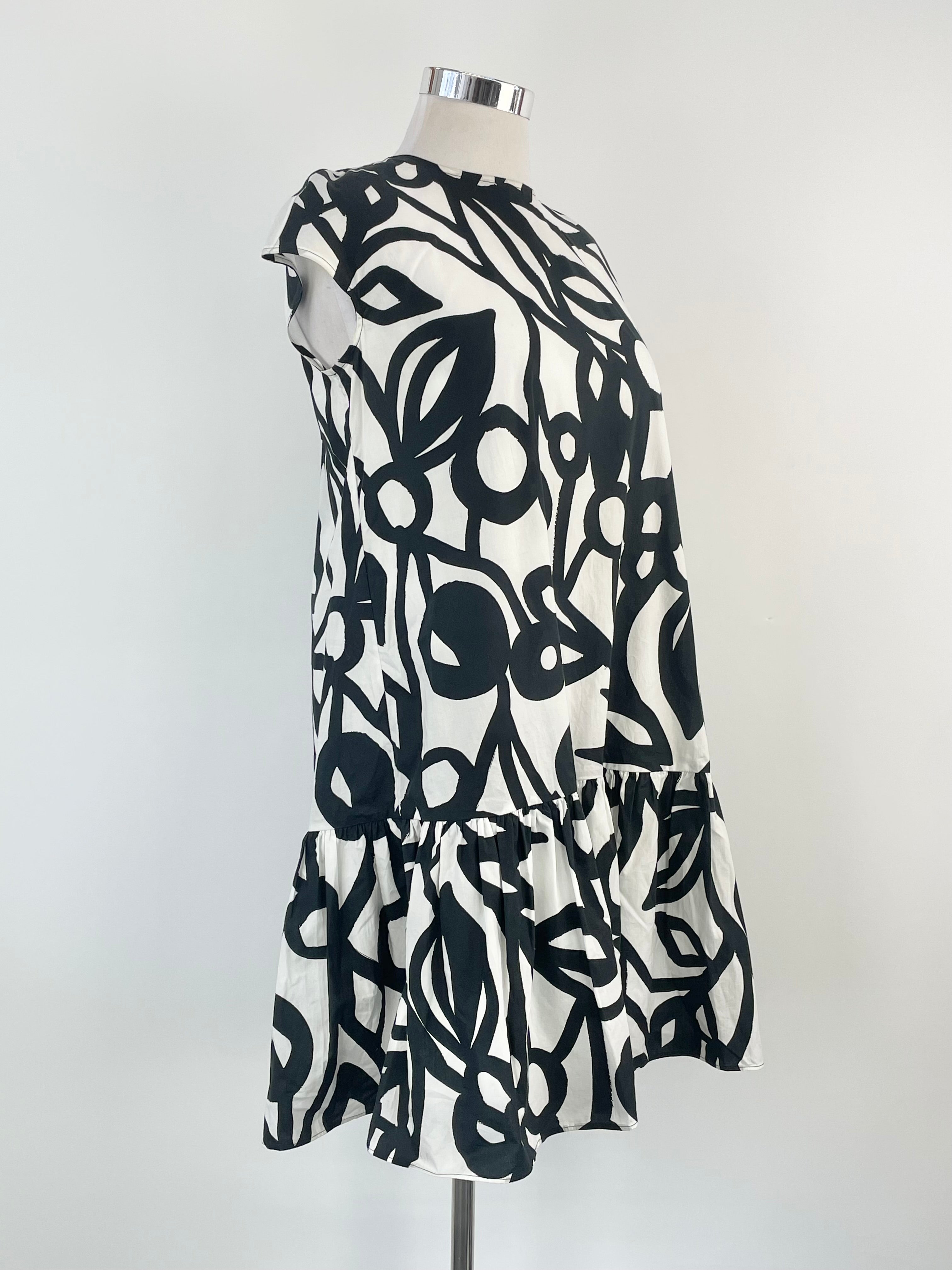 A sleeveless mini dress with a white and black geometric pattern, displayed on a mannequin.