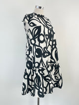 A sleeveless mini dress with a white and black geometric pattern, displayed on a mannequin.