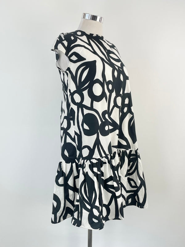 A sleeveless mini dress with a white and black geometric pattern, displayed on a mannequin.