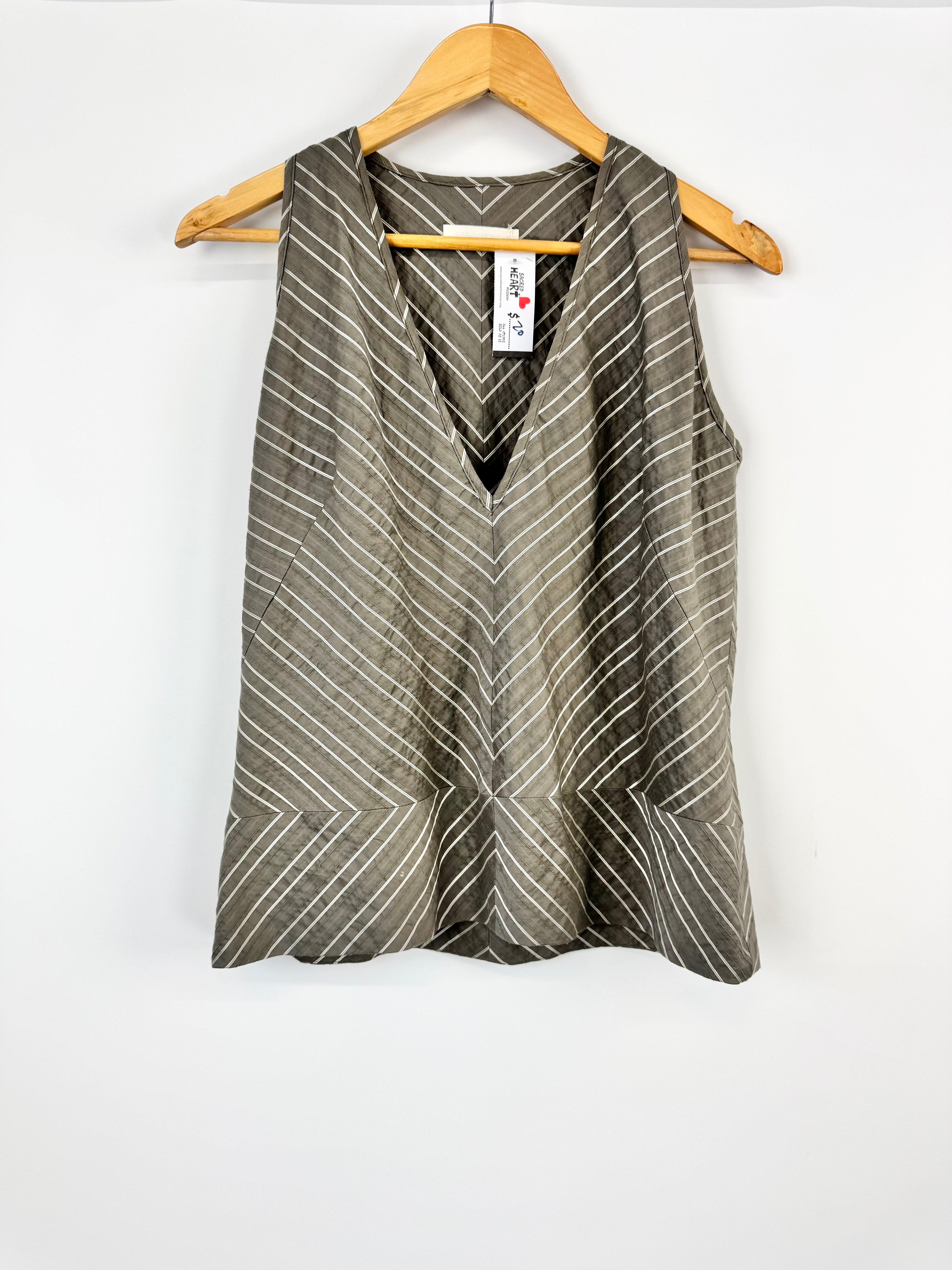 Sleeveless top with geometric pattern on a hanger against a white background