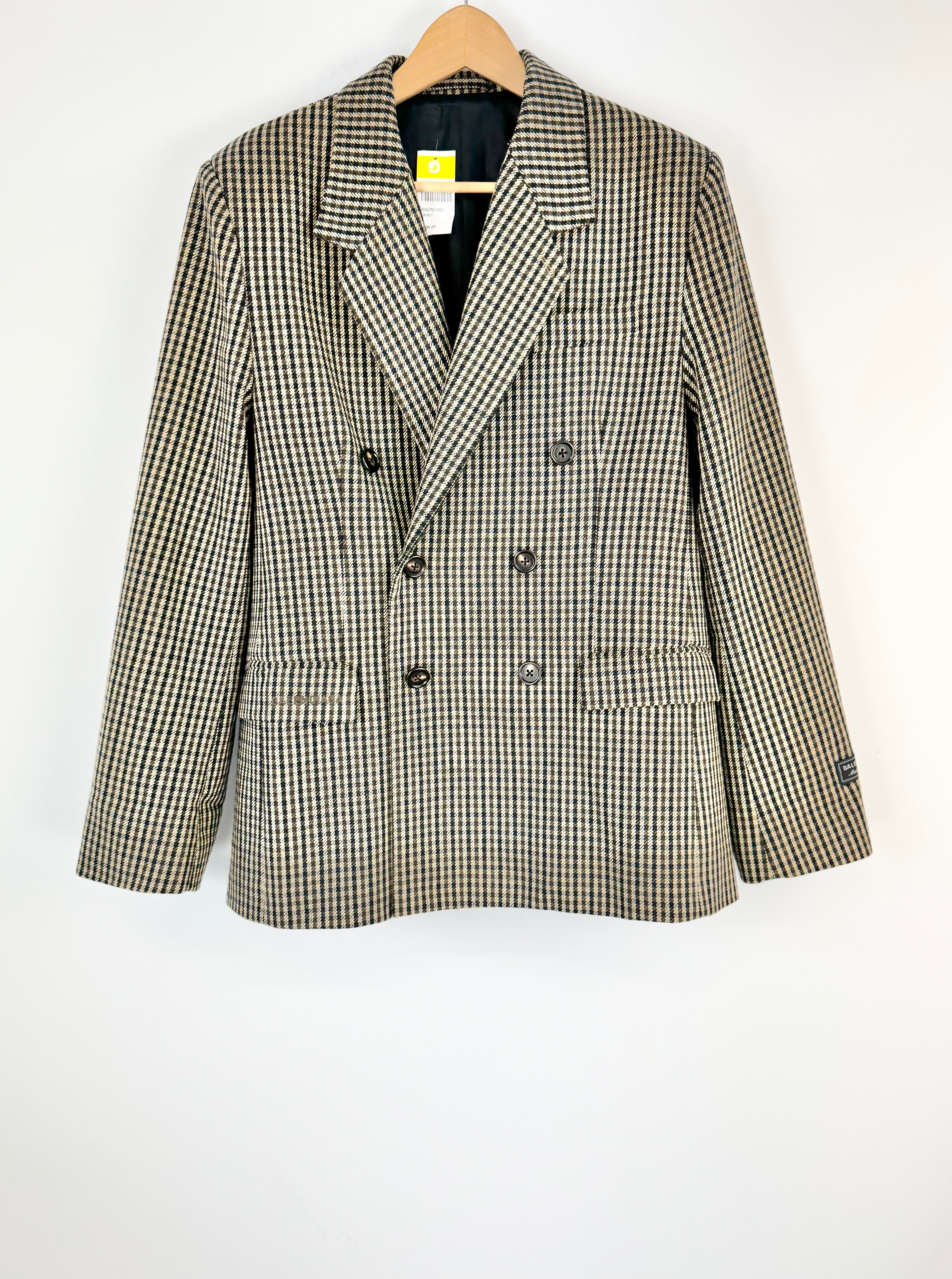 Plaid blazer on a hanger against a white background