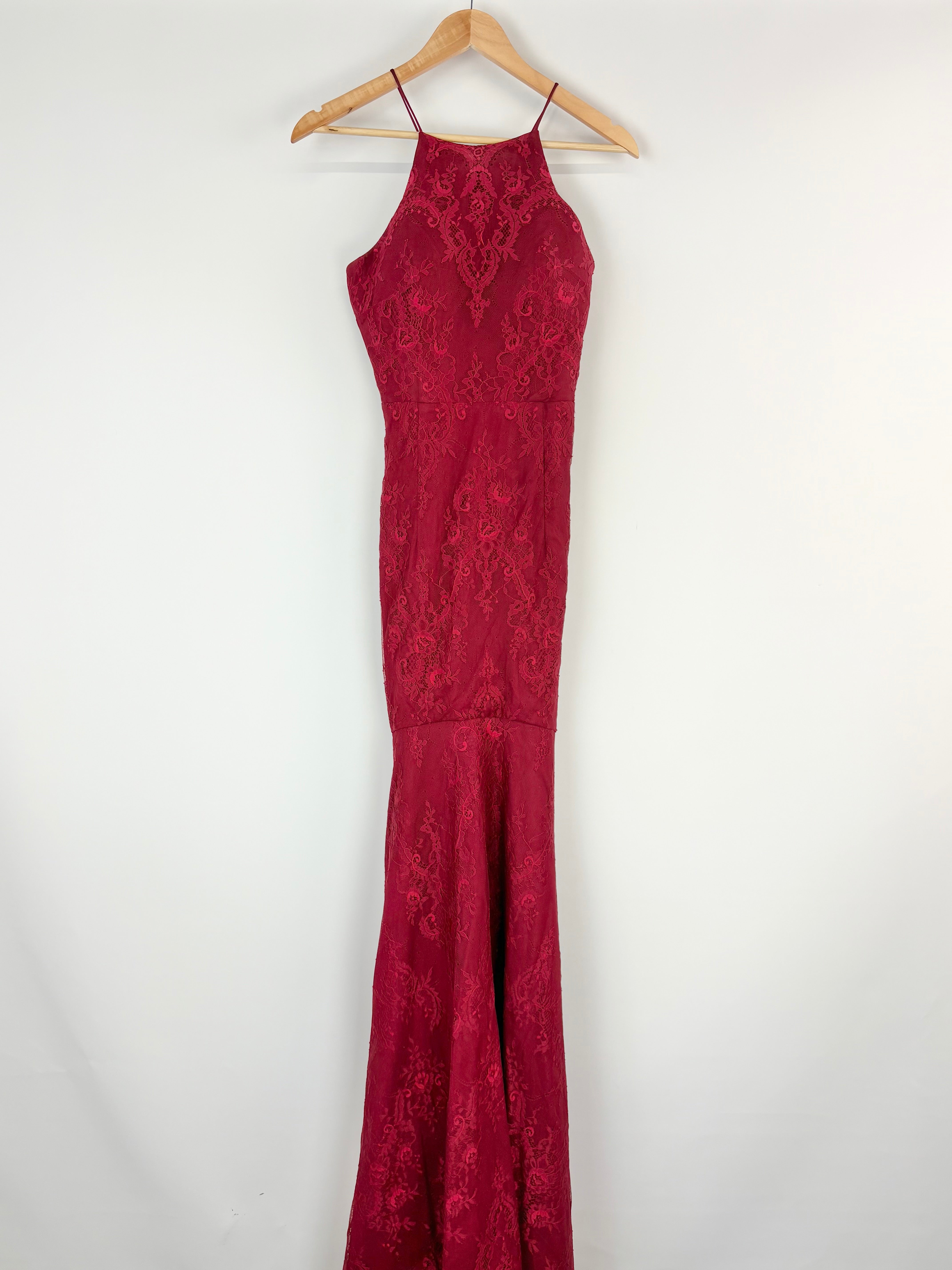 Red lace dress on a hanger against a white background