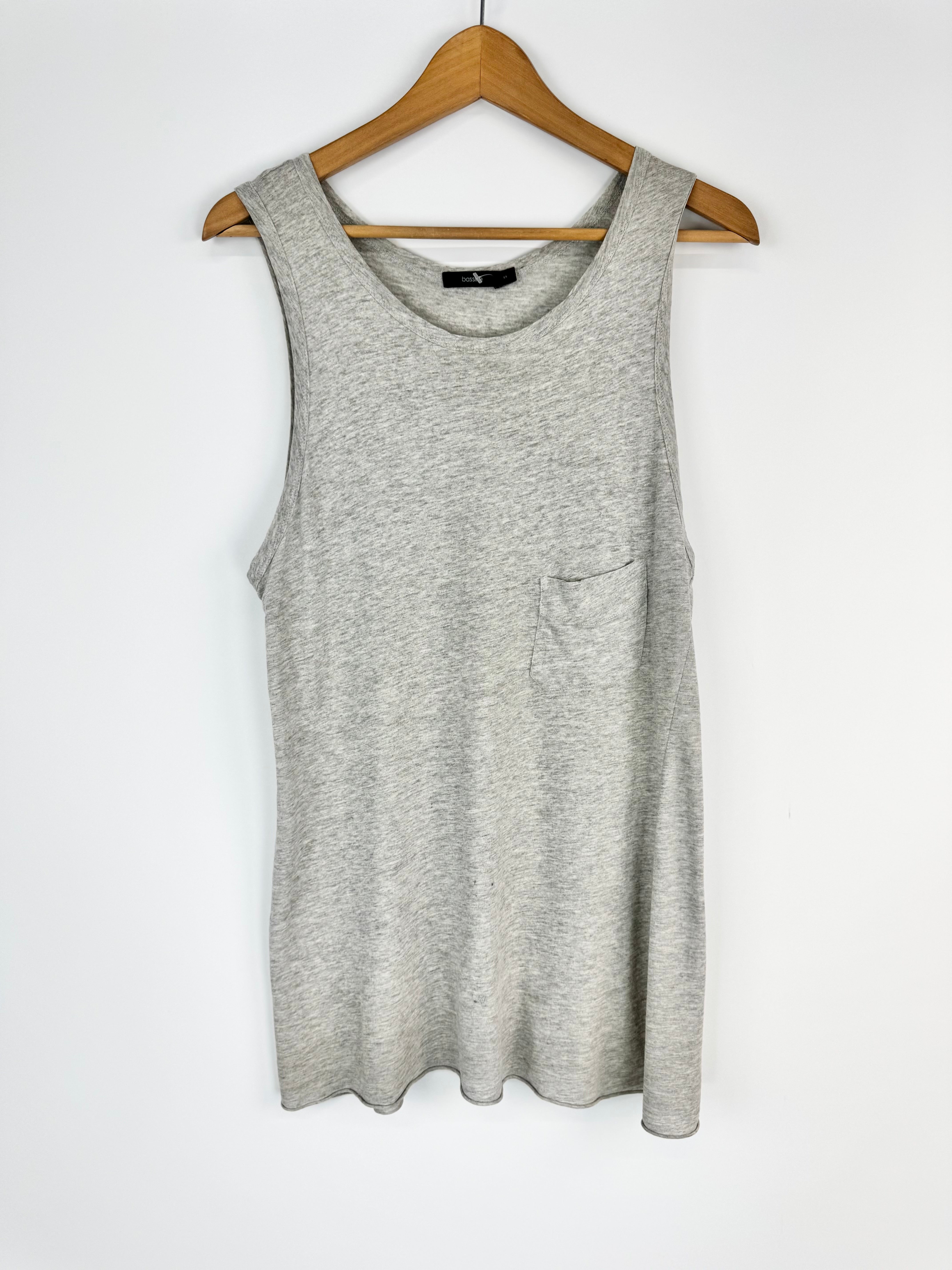 Gray sleeveless top on a wooden hanger against a white background