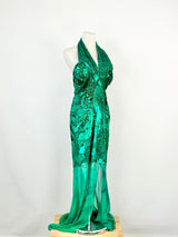 An emerald green silk maxi dress with sequin and bead embroidery on a mannequin against a white background.