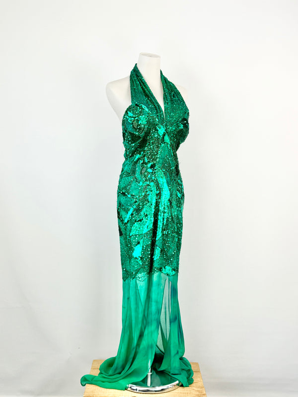 An emerald green silk maxi dress with sequin and bead embroidery on a mannequin against a white background.