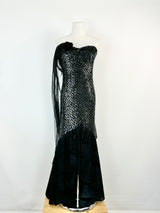 Black evening gown with sequin detailing on a mannequin against a white background