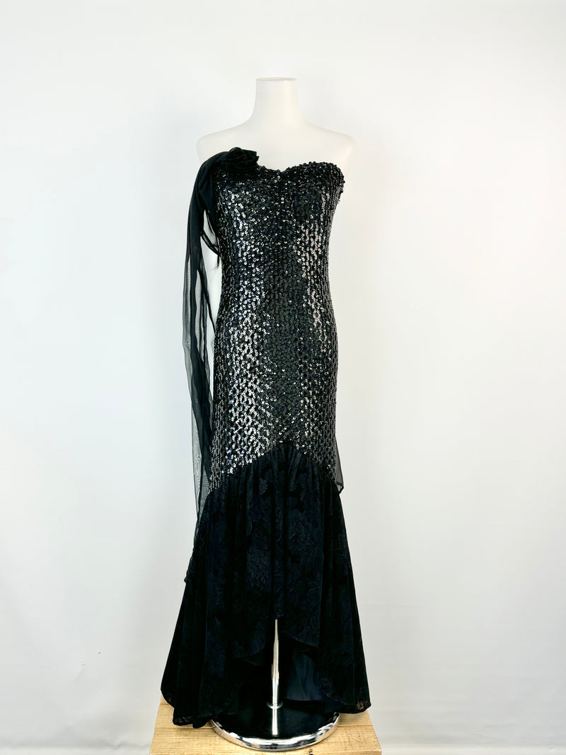 Black evening gown with sequin detailing on a mannequin against a white background