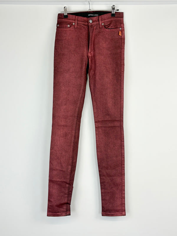 A pair of red tinsle coated skinny leggings on a hanger, displaying the front view.