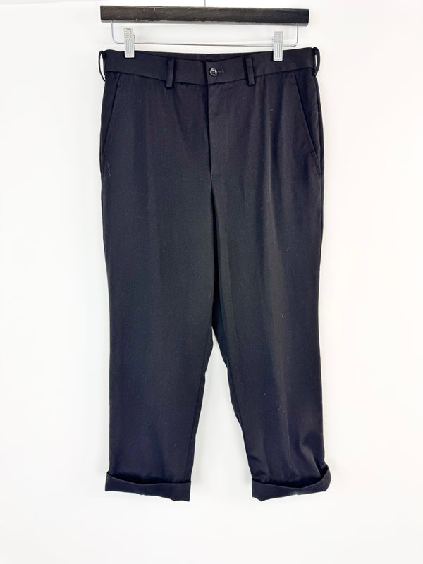 Black pants hanging on a white background