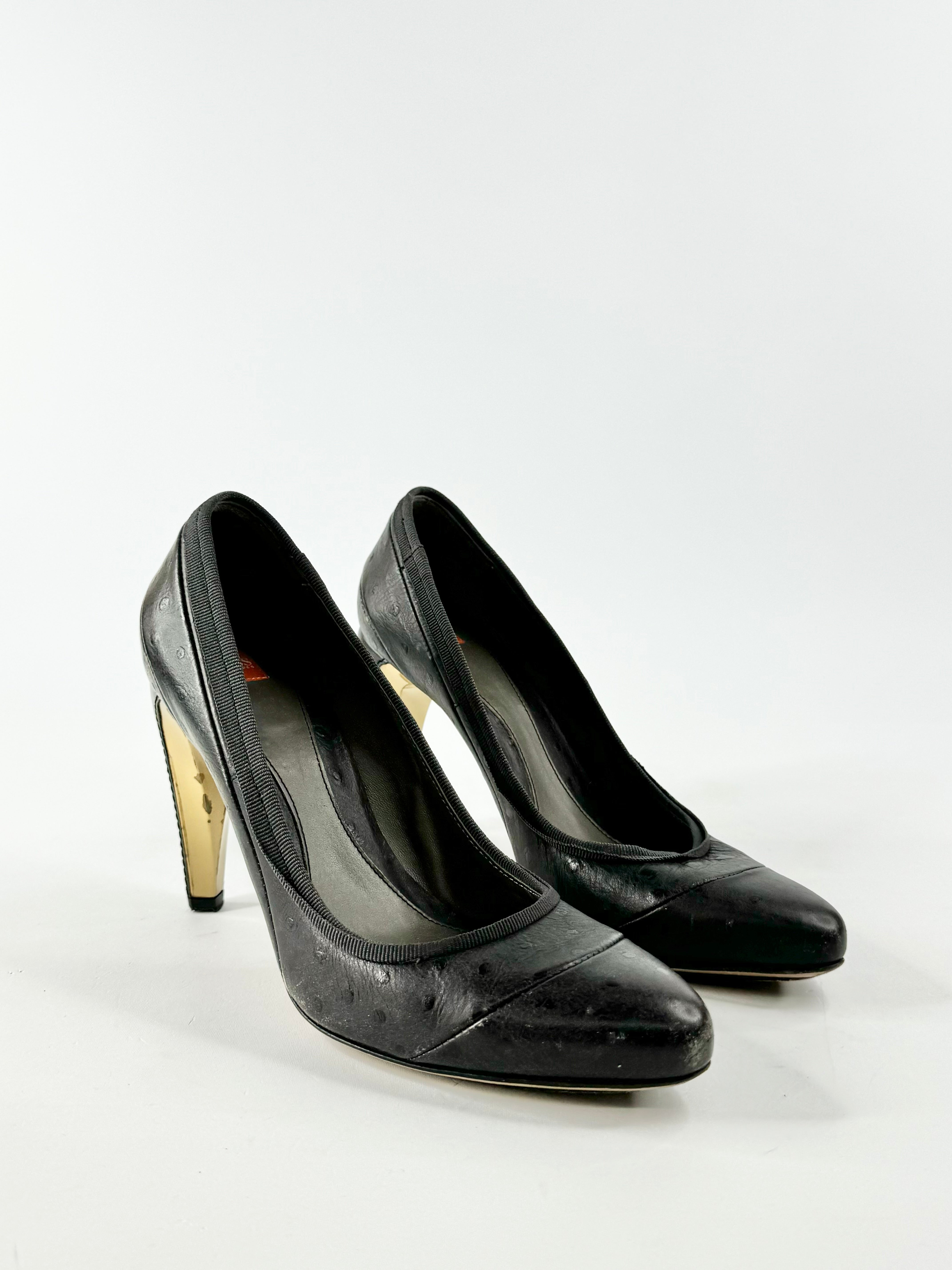 A pair of black high-heeled pumps with a pointed toe. The heels are visible and appear to be around 10cm in height.