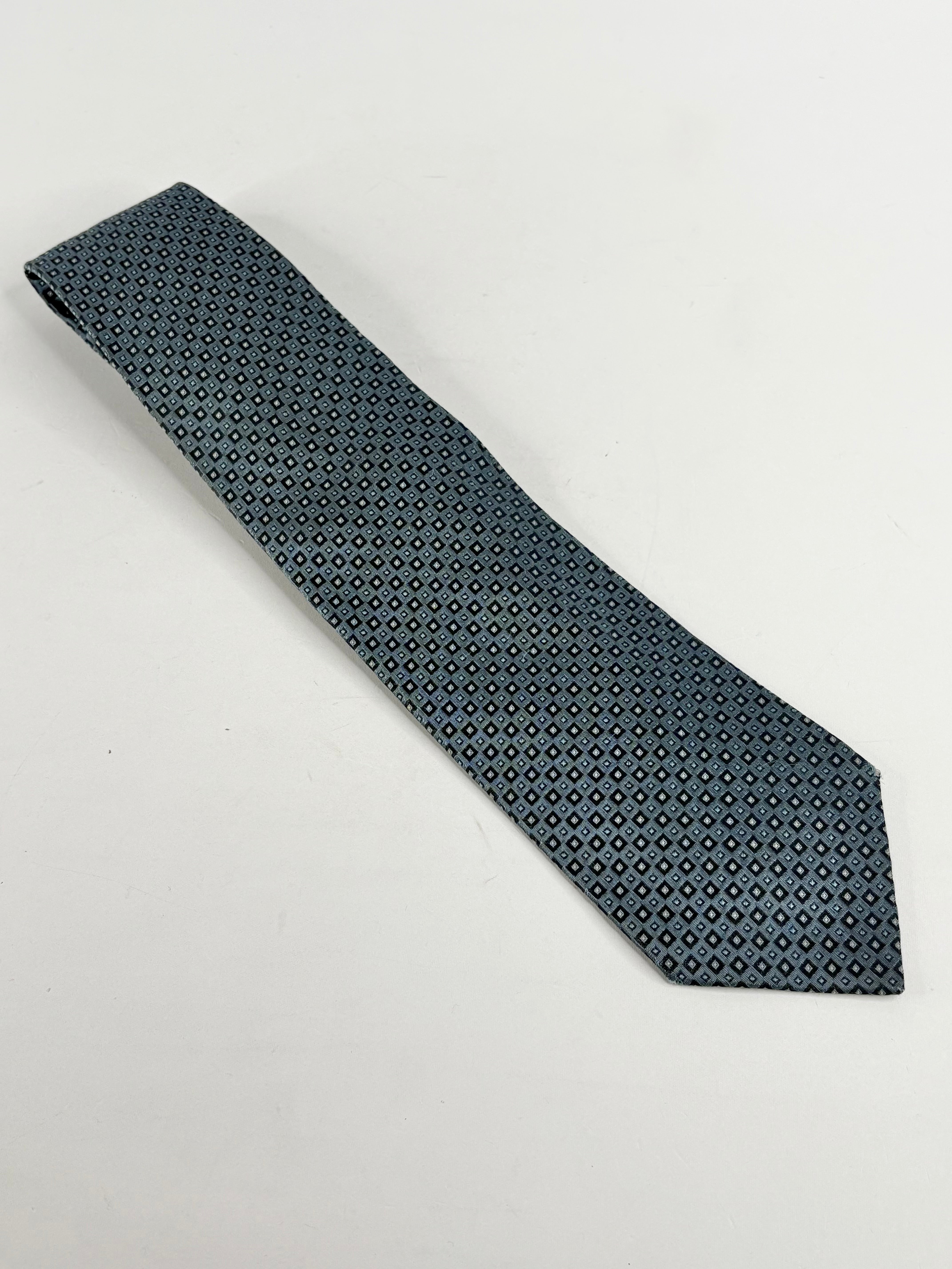 A steel blue silk tie with a geometric square pattern, displayed on a plain background.