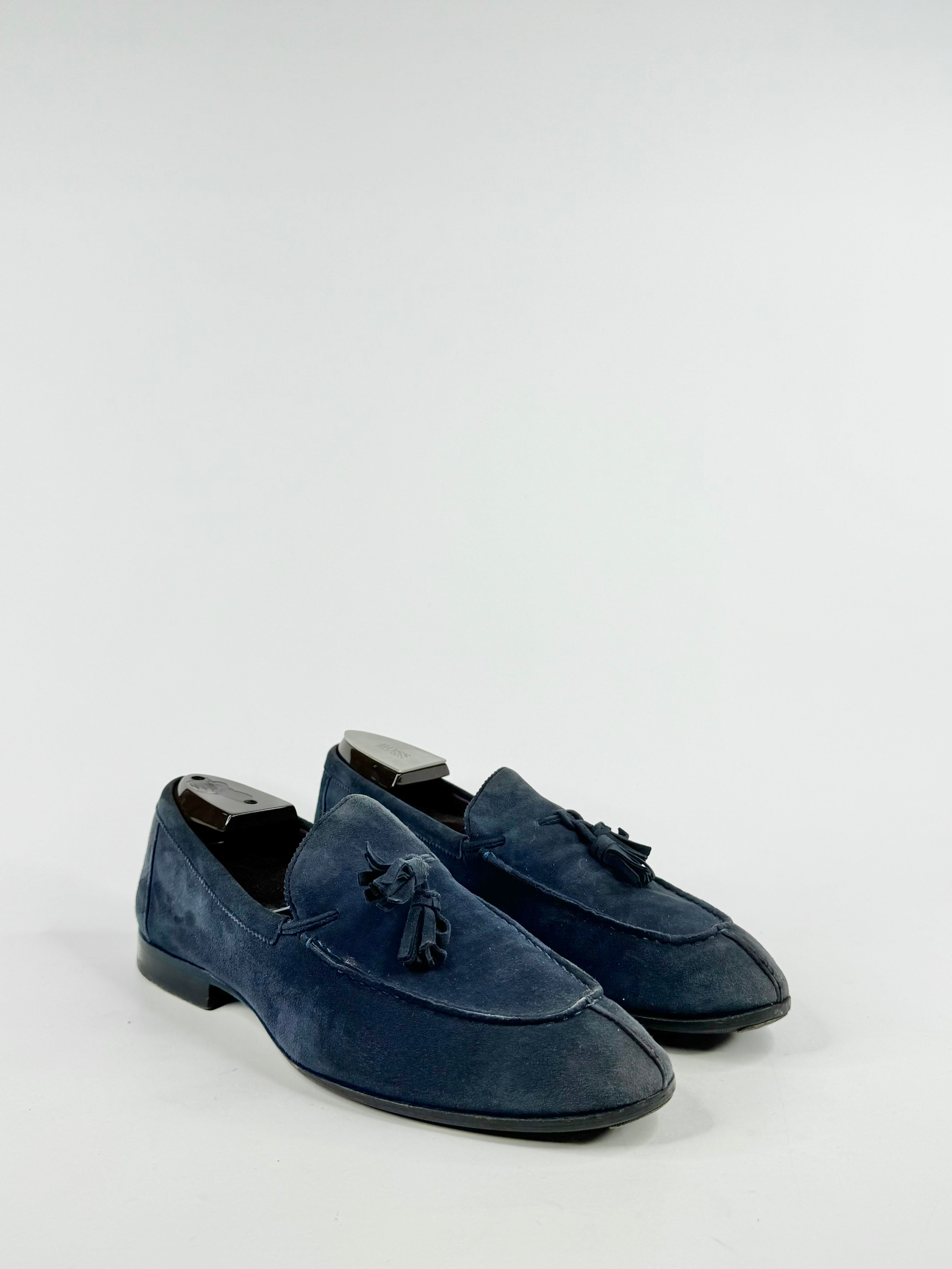 Pair of blue suede loafers on a light gray background