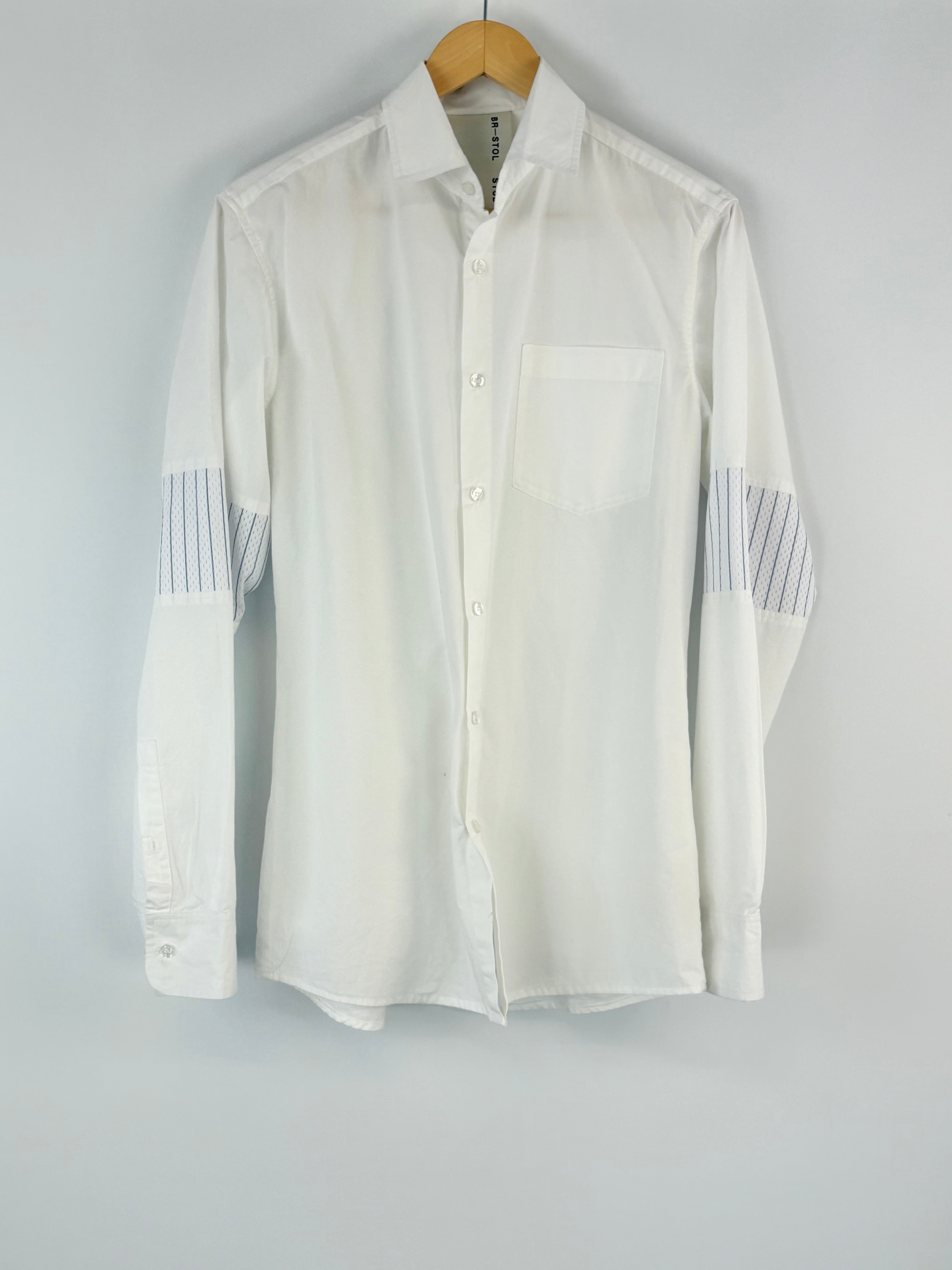 White shirt with gray accents on sleeves and collar hanging on a gray background