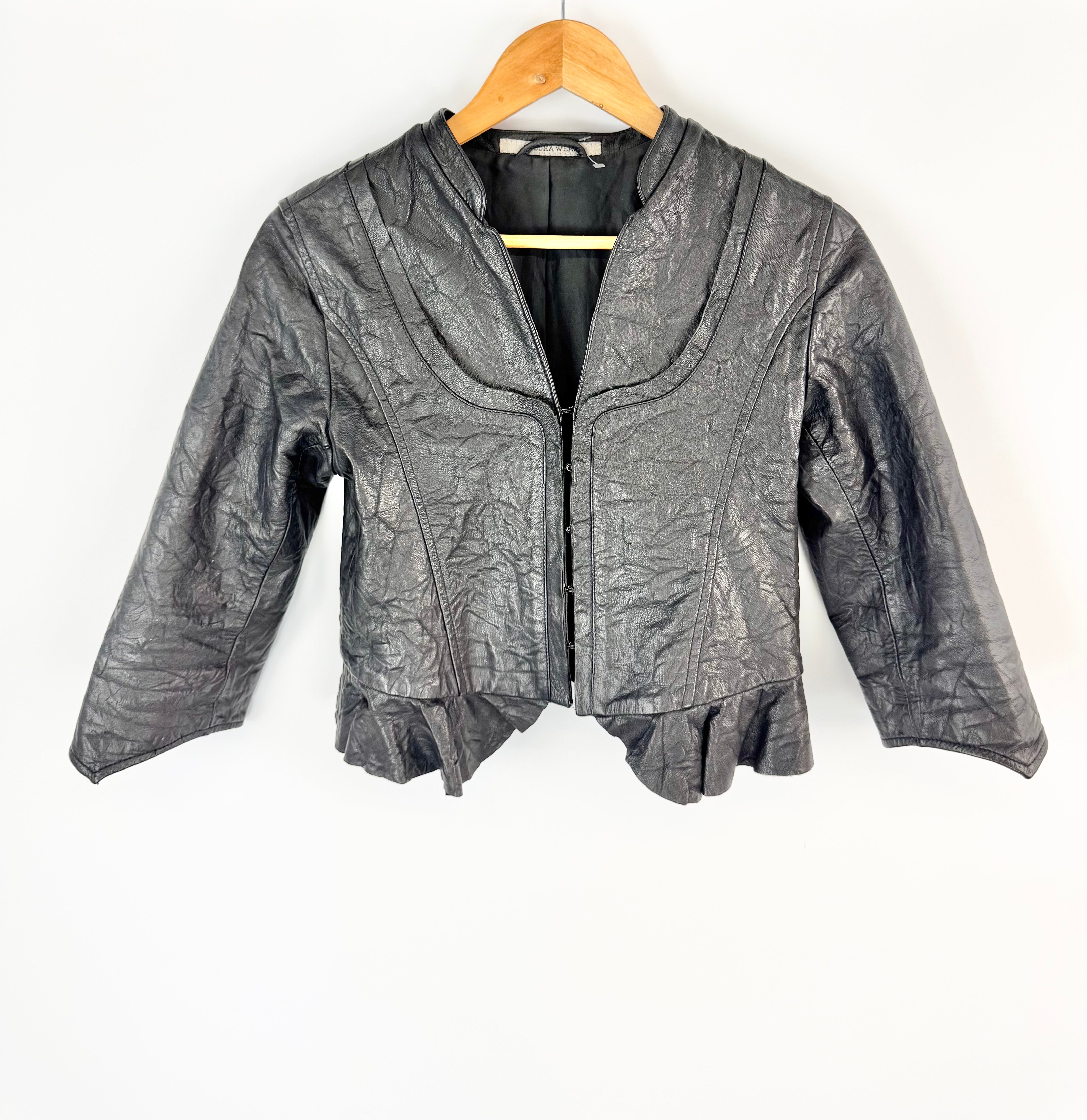 Black leather jacket on a wooden hanger against a white background