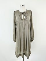 A cream and black grid pattern silk dress with long sleeves, a high rounded neckline, and decorative 'bobbles' on the front bust, displayed on a mannequin.