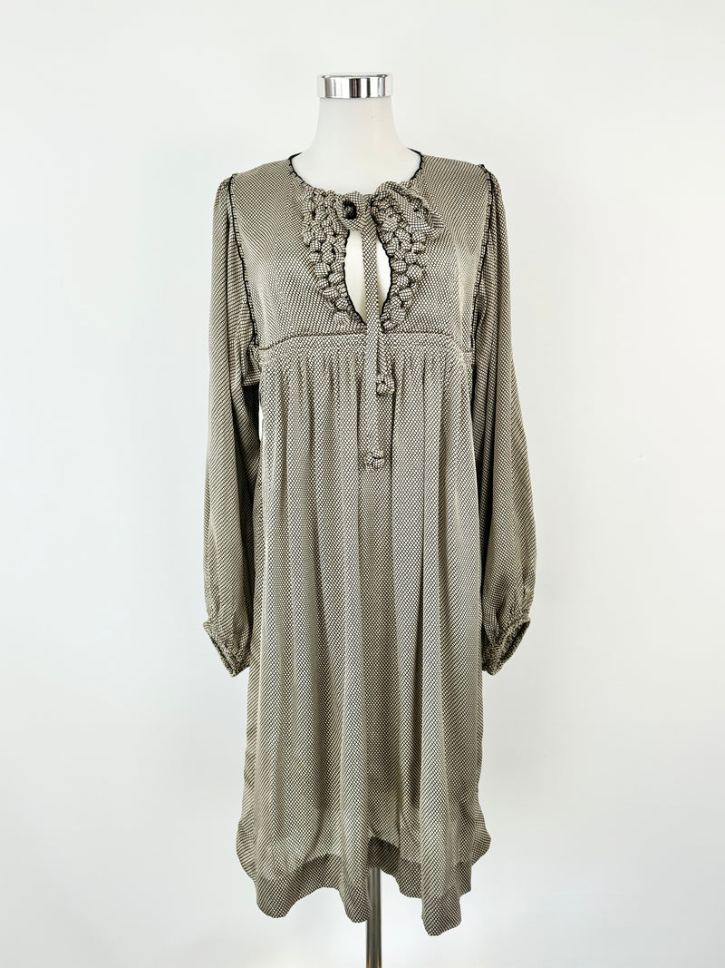 A cream and black grid pattern silk dress with long sleeves, a high rounded neckline, and decorative 'bobbles' on the front bust, displayed on a mannequin.