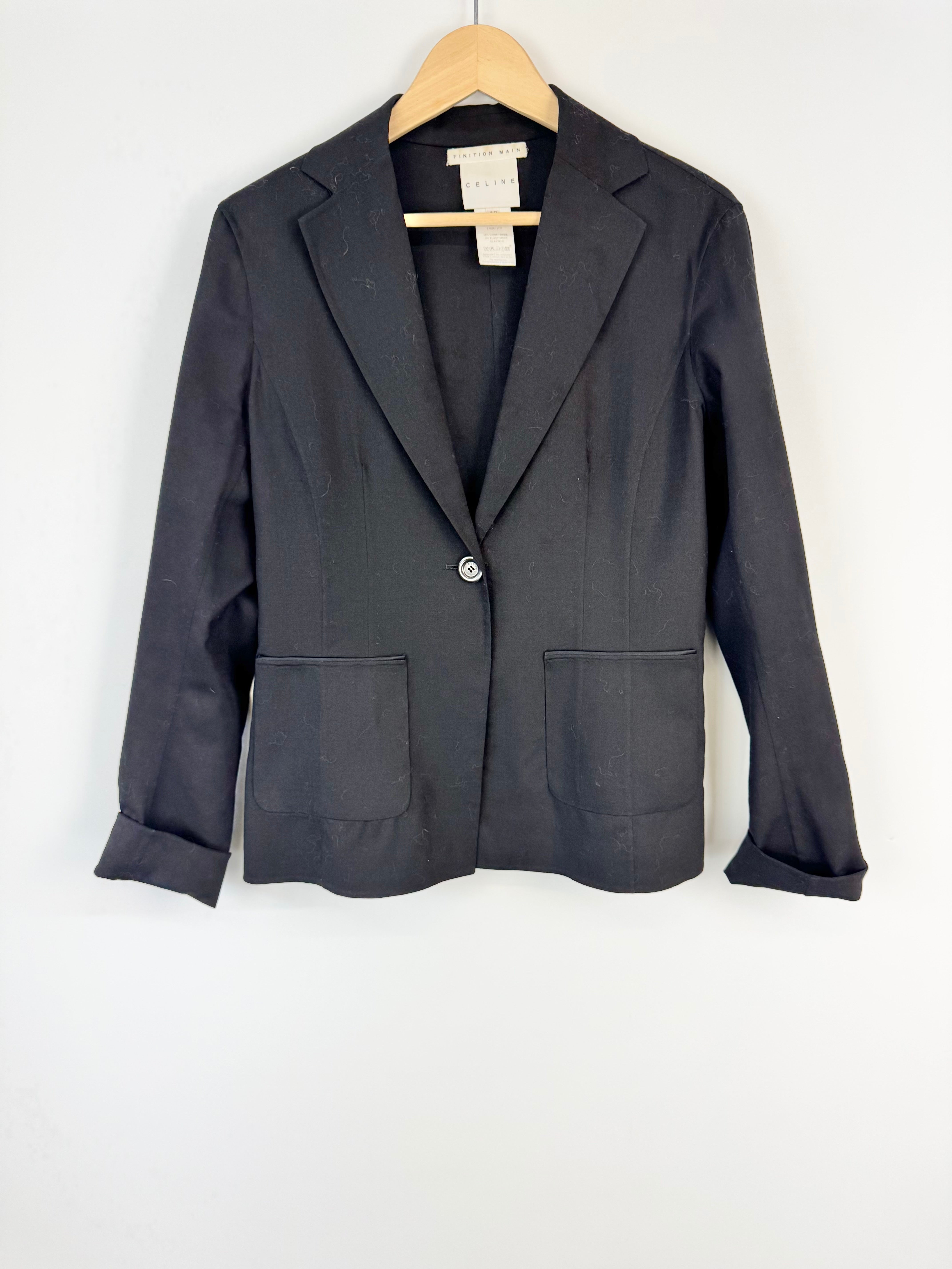 Black blazer on a wooden hanger against a white background