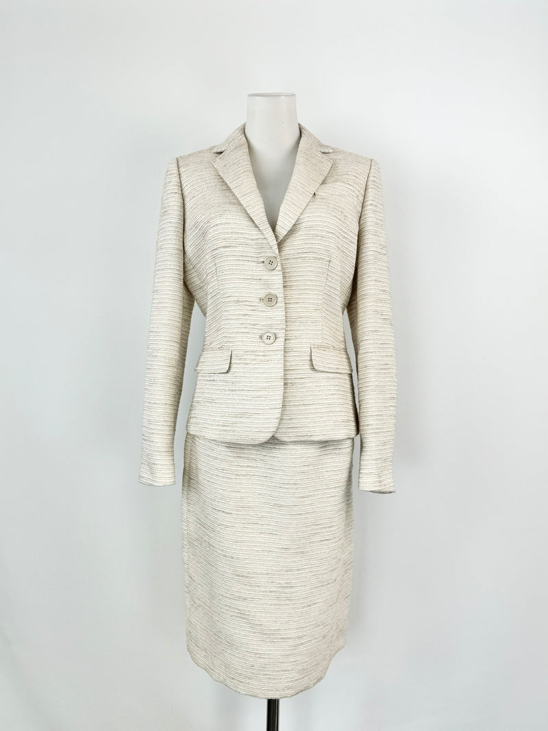 A Calvin Klein silver, white, and cream woven two-piece suit consisting of a blazer and a pencil skirt, displayed on a mannequin.