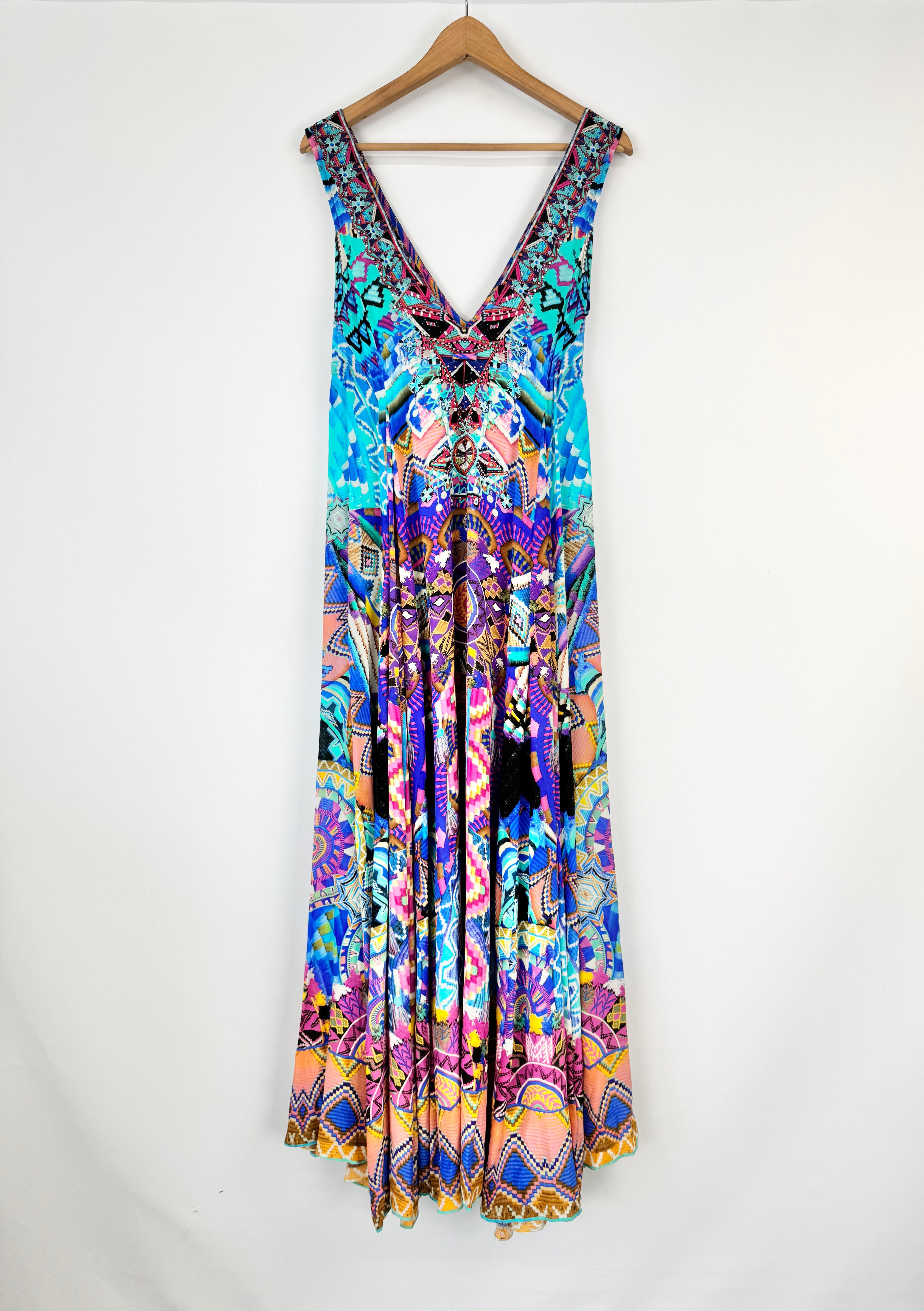 Colorful patterned dress on a hanger against a white background
