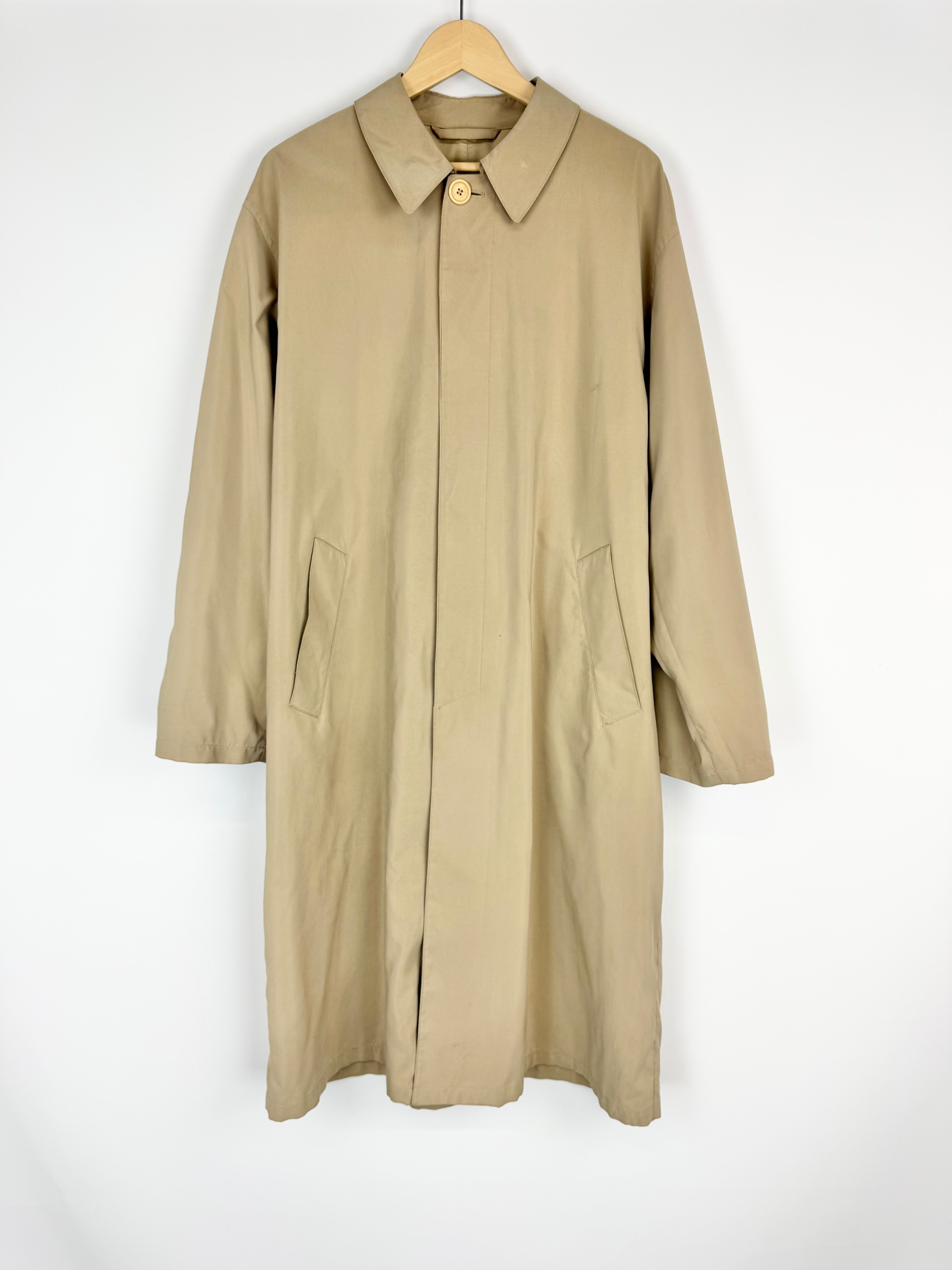 Beige trench coat on a hanger against a white background