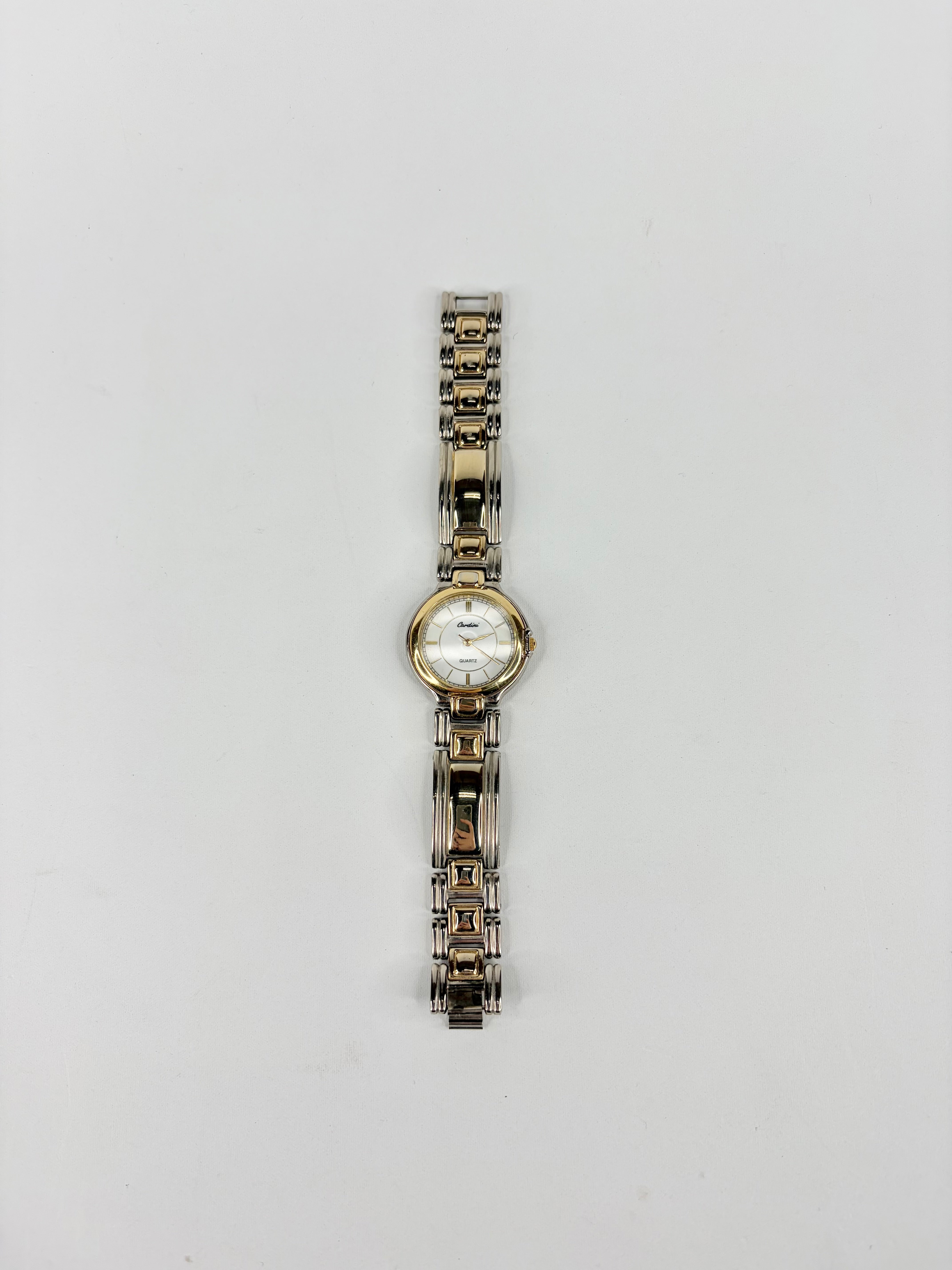 Wristwatch with a metal band on a light gray background