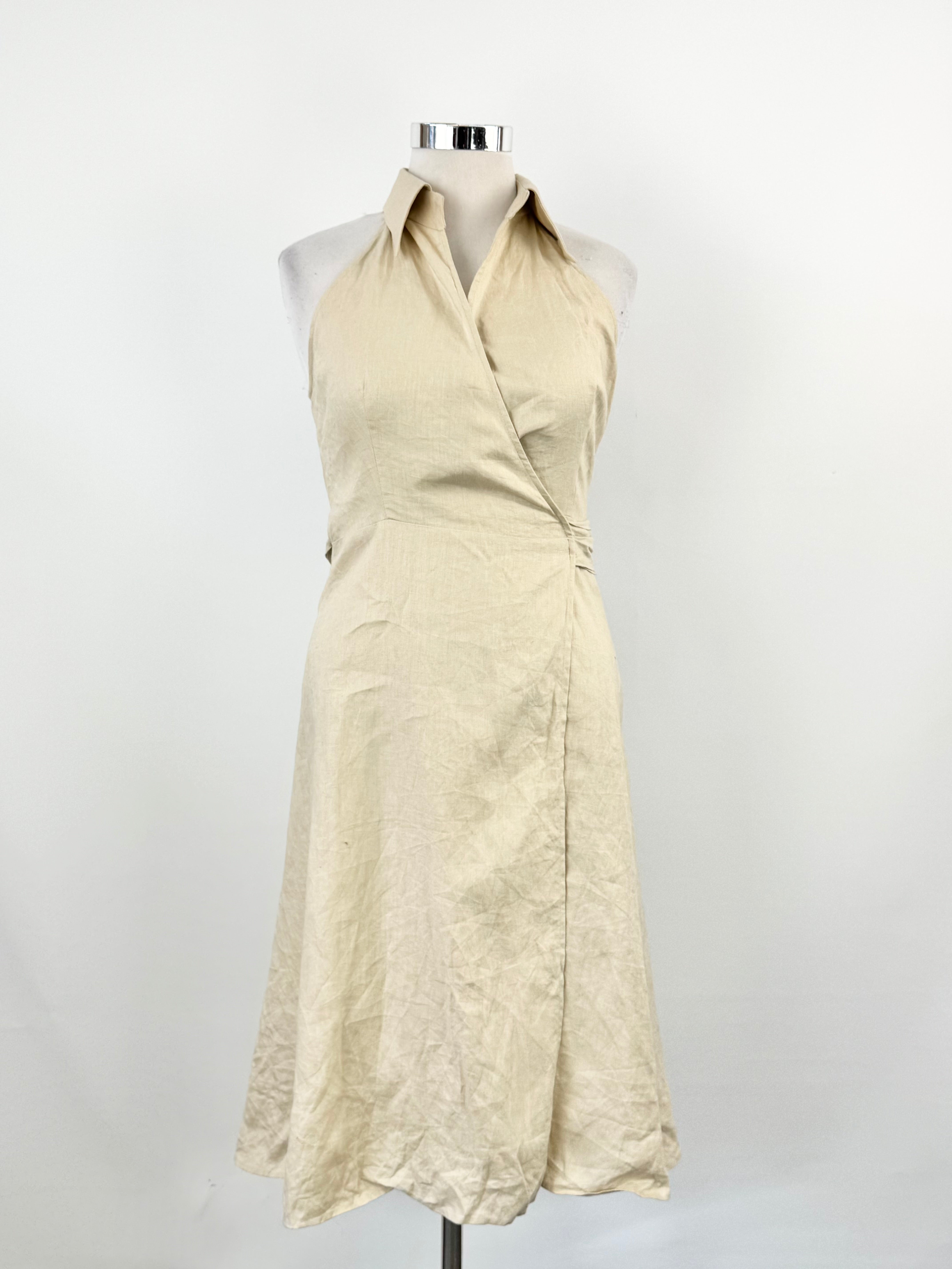 Beige halter neck dress on a mannequin against a white background