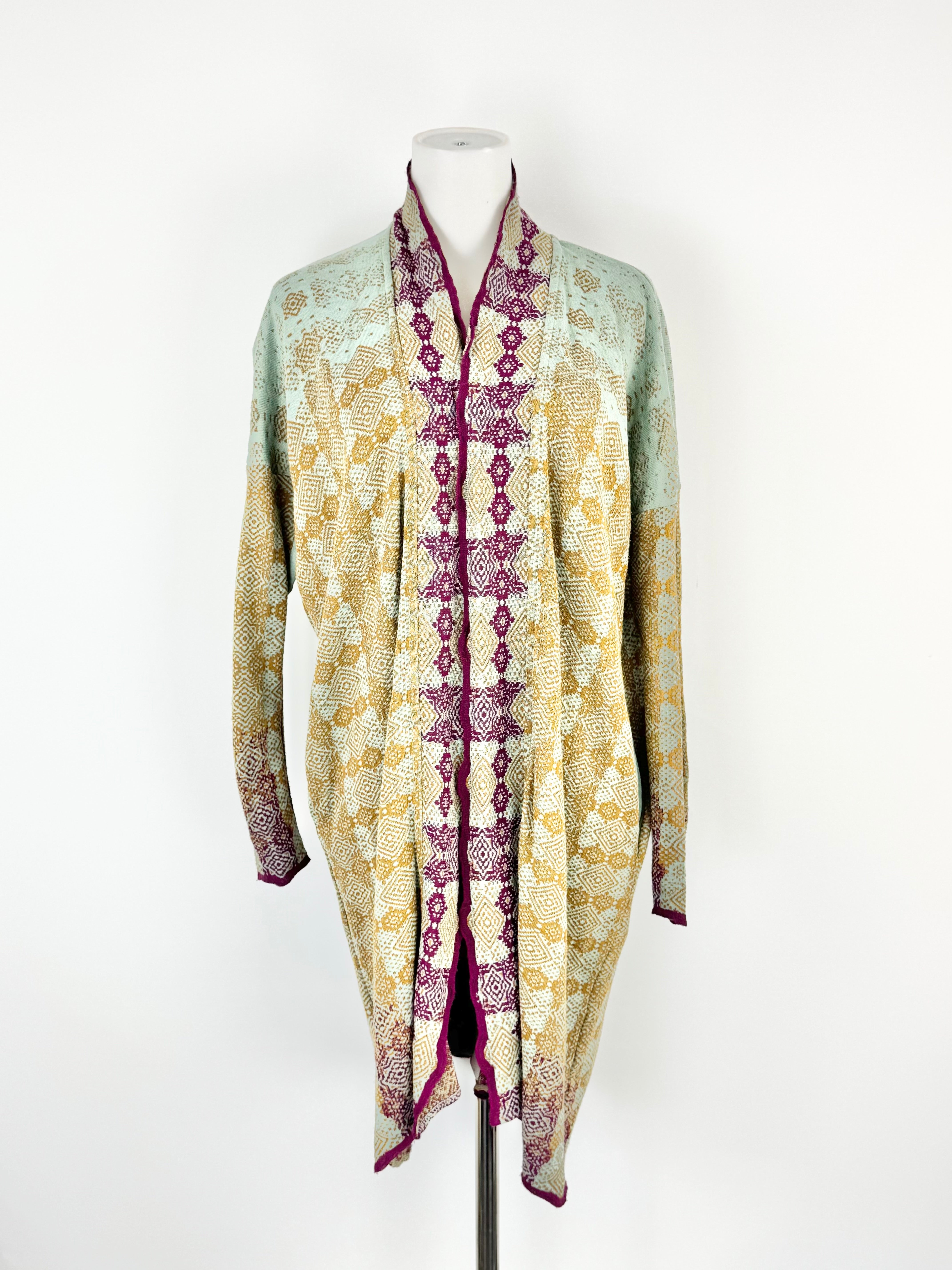 Long, patterned scarf on a mannequin against a white background