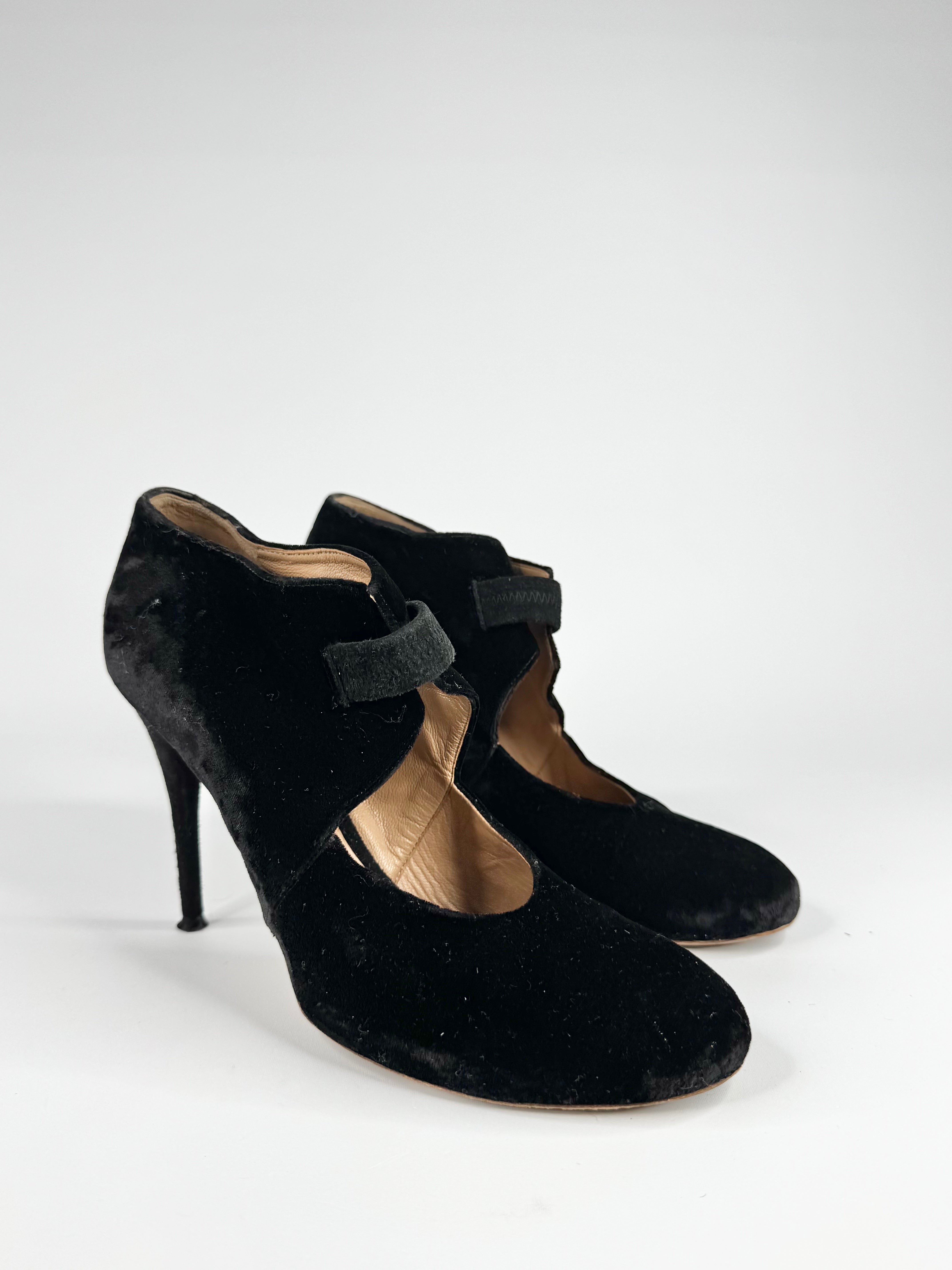 Black high-heeled shoes with bow details on a white background