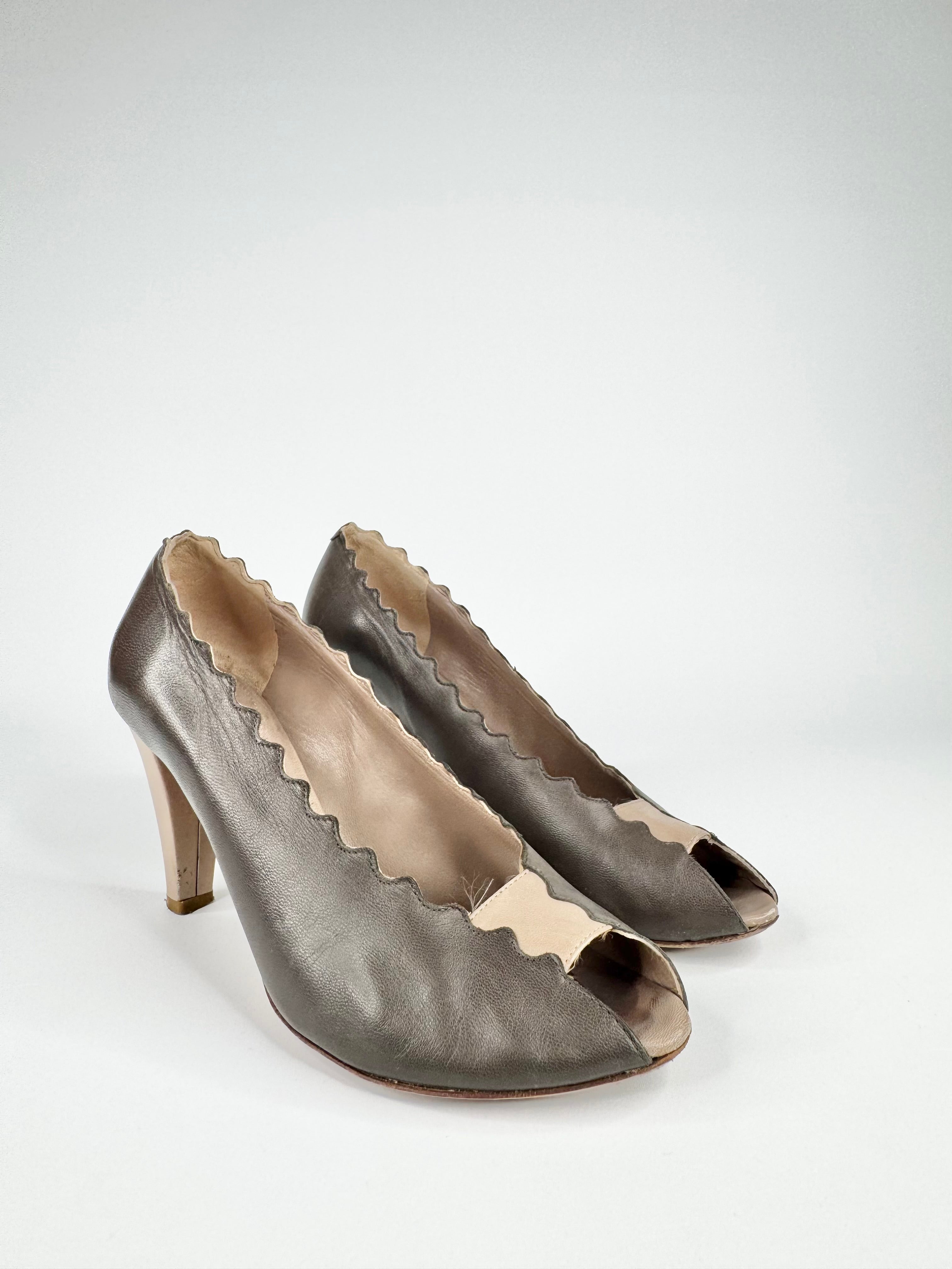 Pair of metallic high-heeled shoes with peep-toe design on a white background