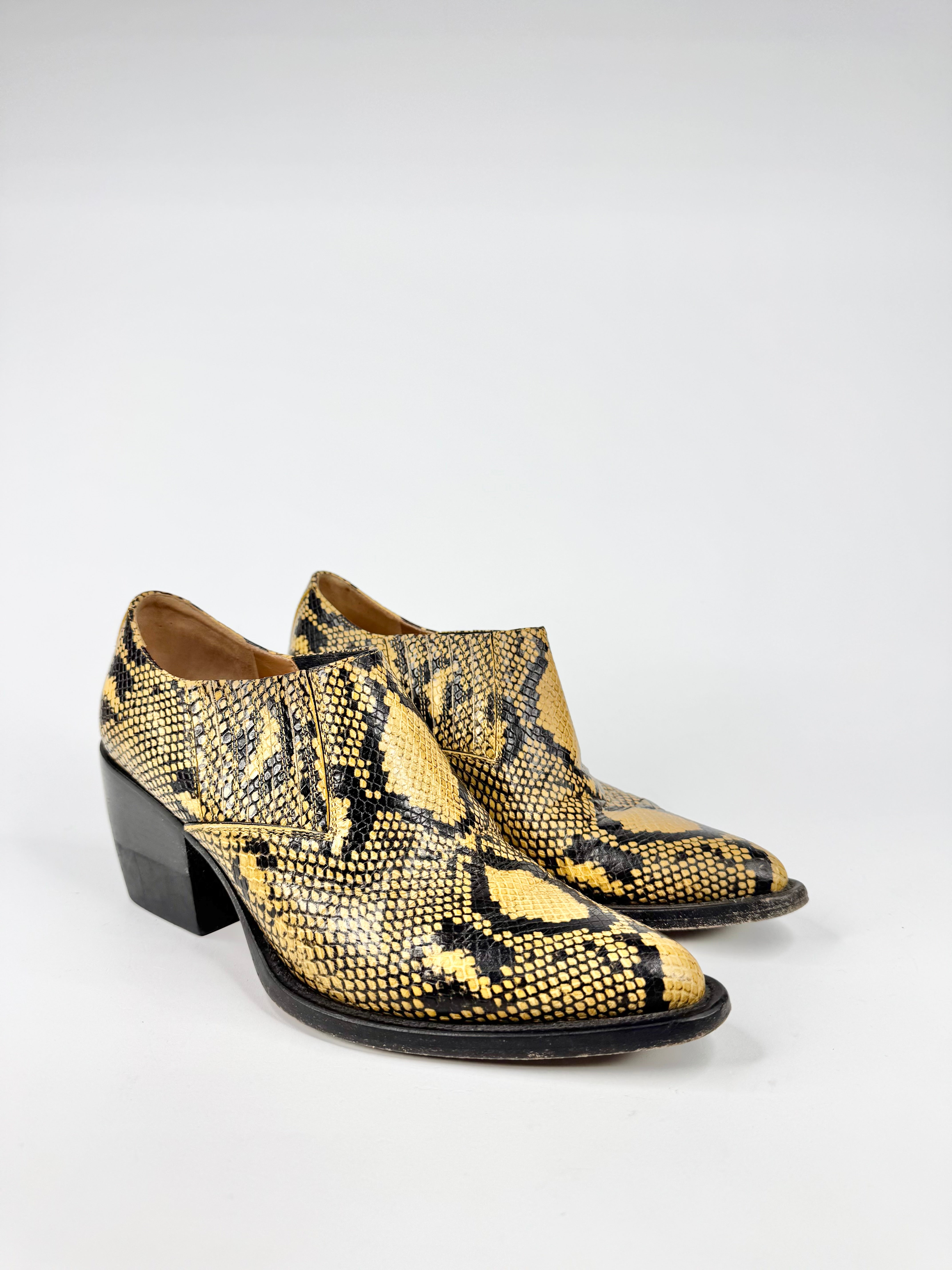 Pair of snake print boots on a white background