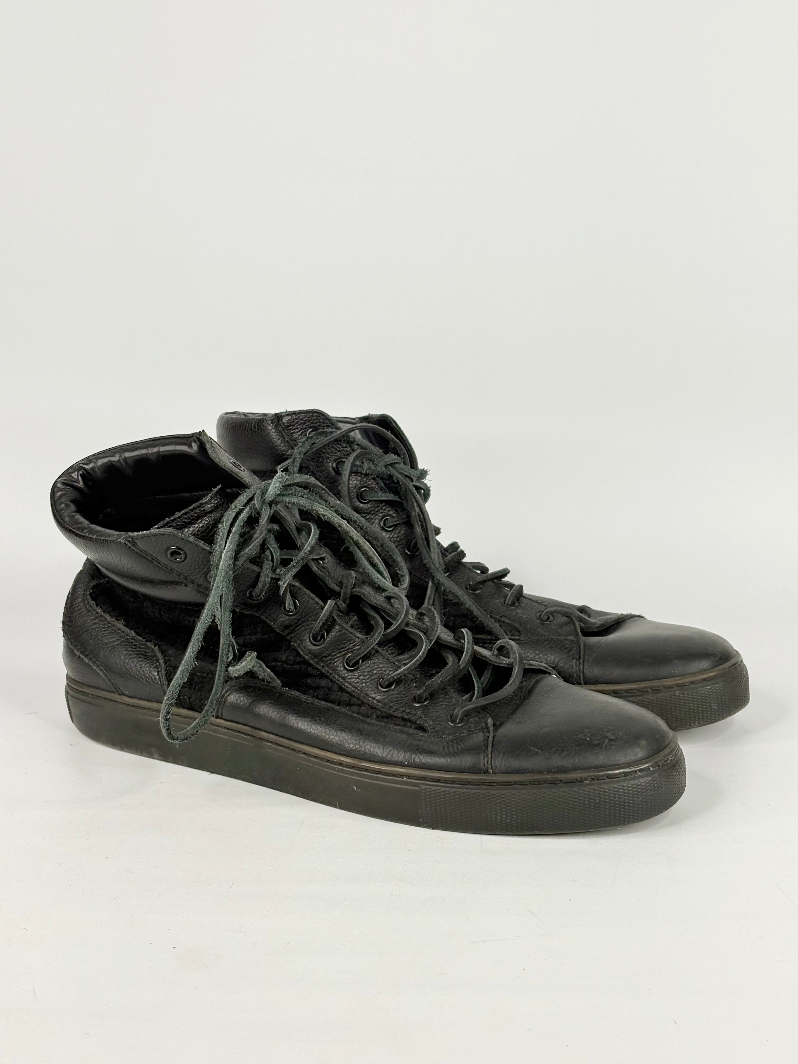 Pair of black high-top sneakers on a white background