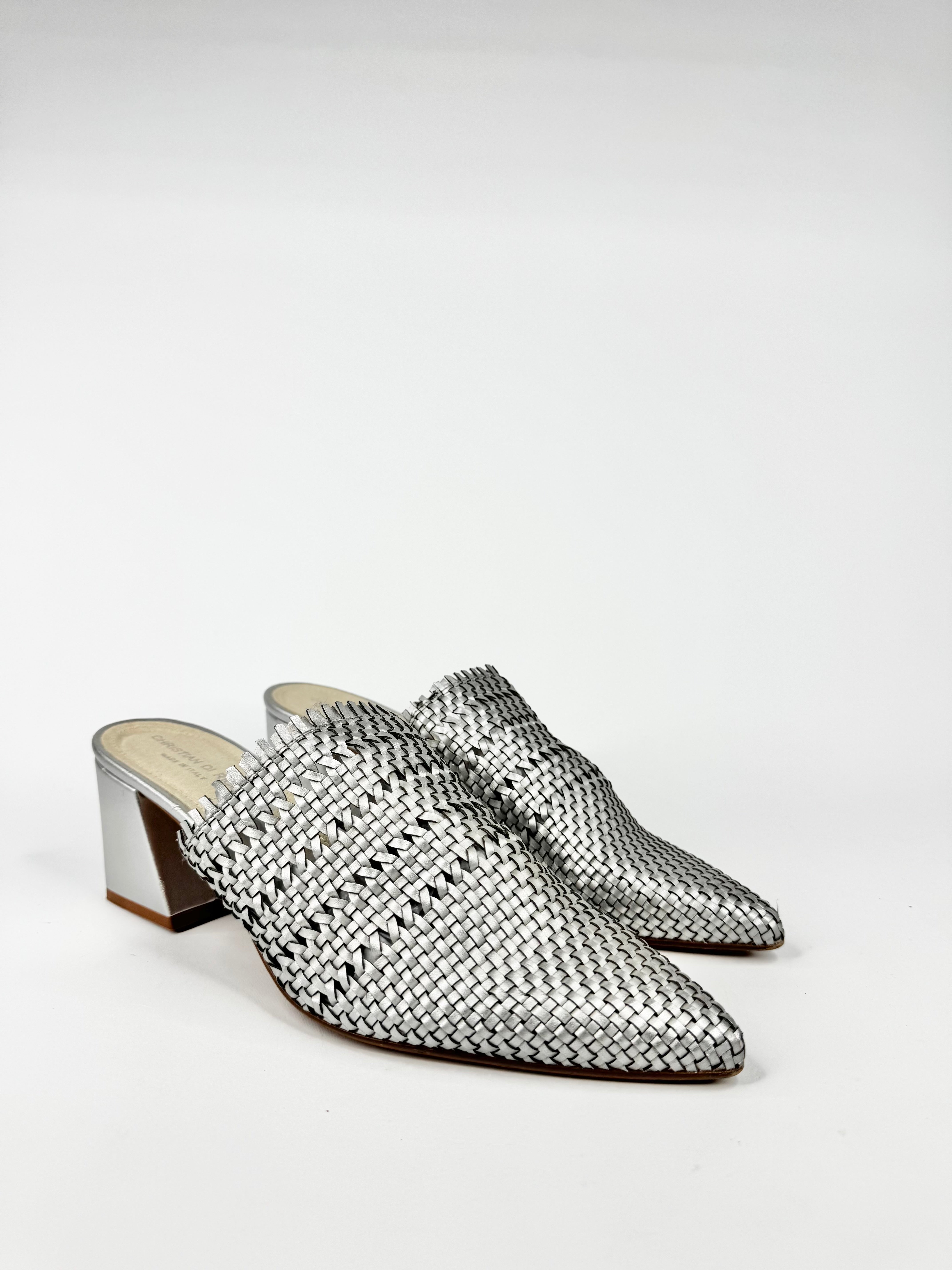 Silver woven high-heeled shoes on a white background