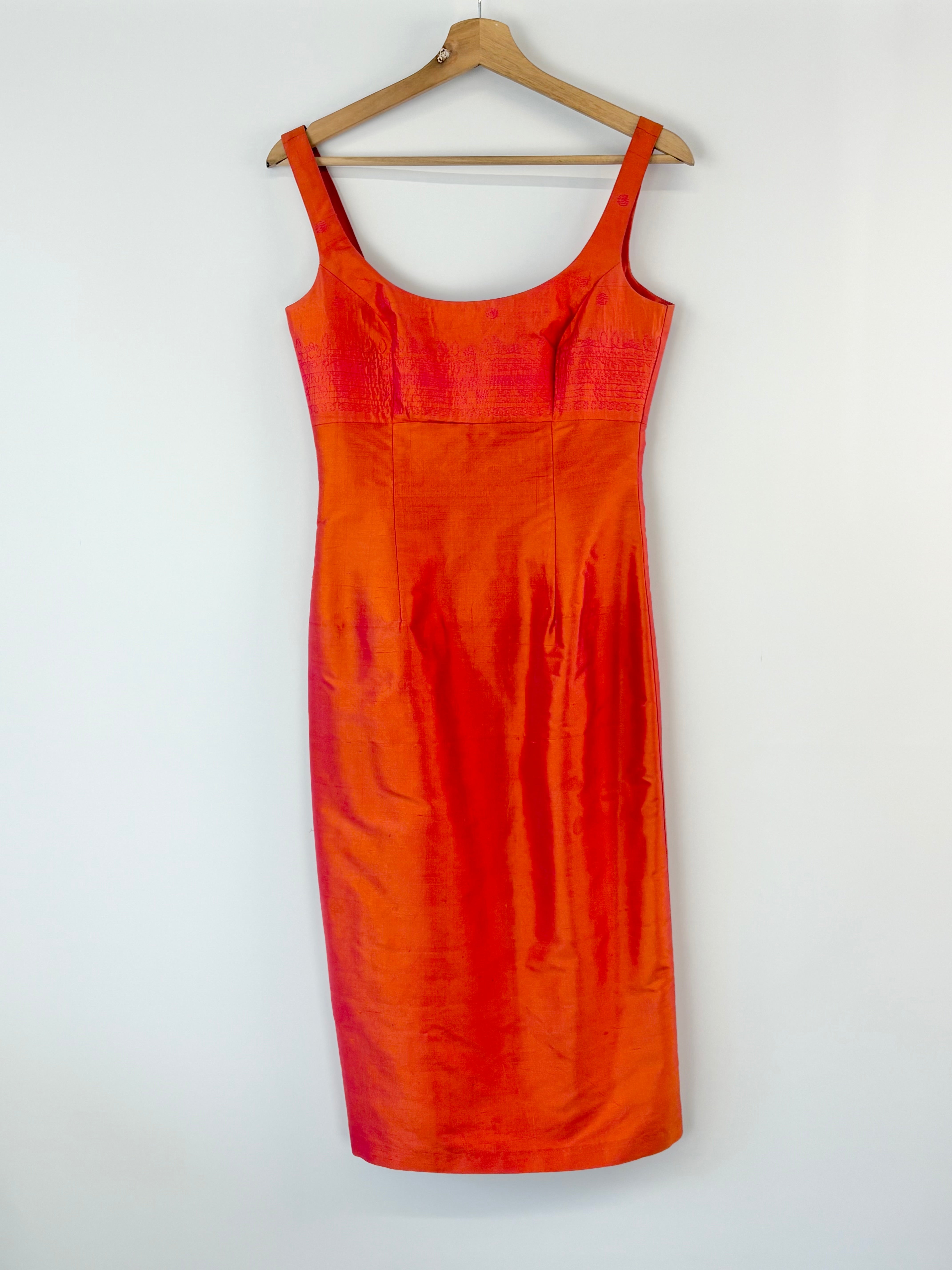 Orange dress on a hanger against a white background