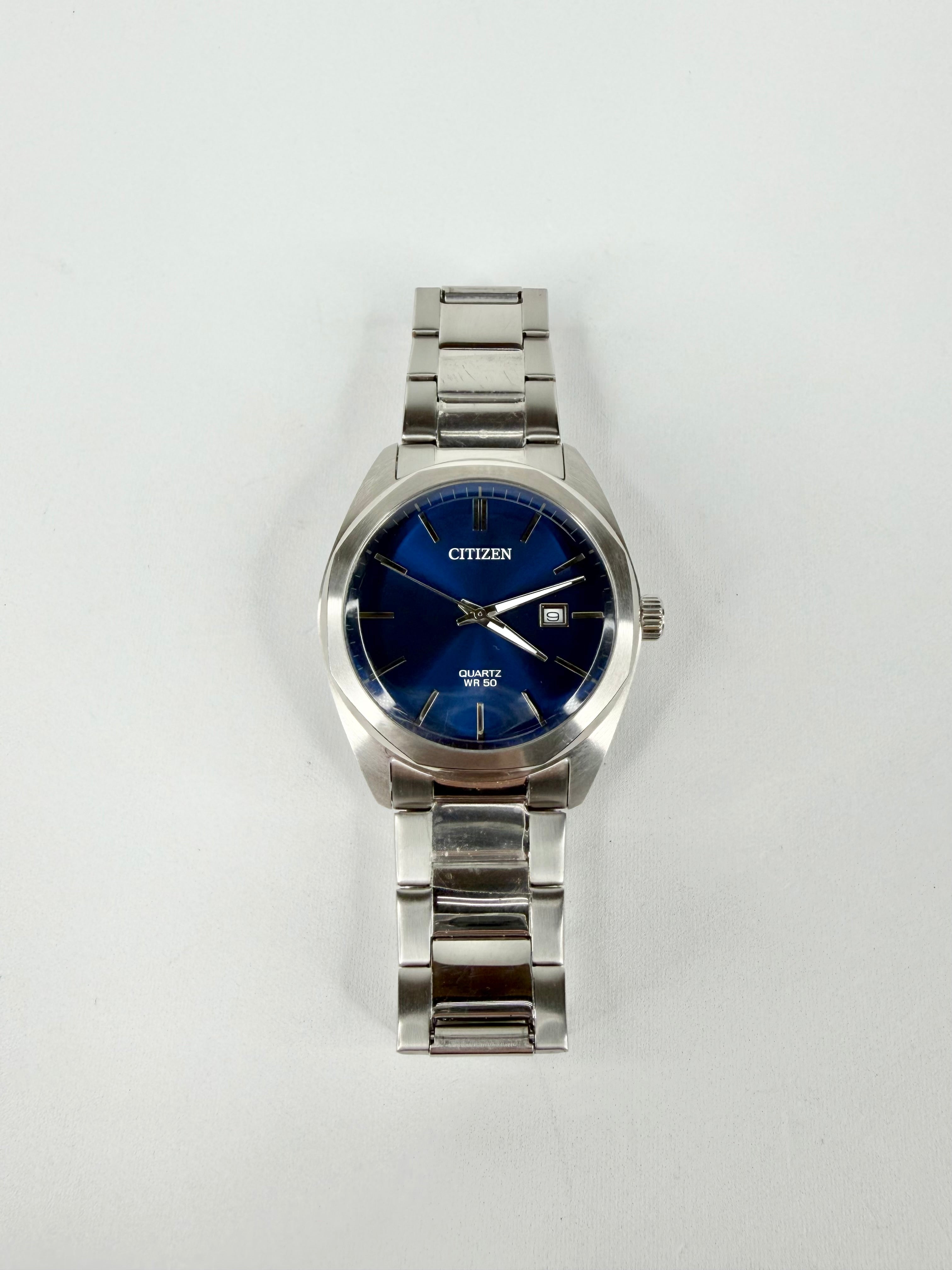 Silver Citizen watch with a blue face on a white background