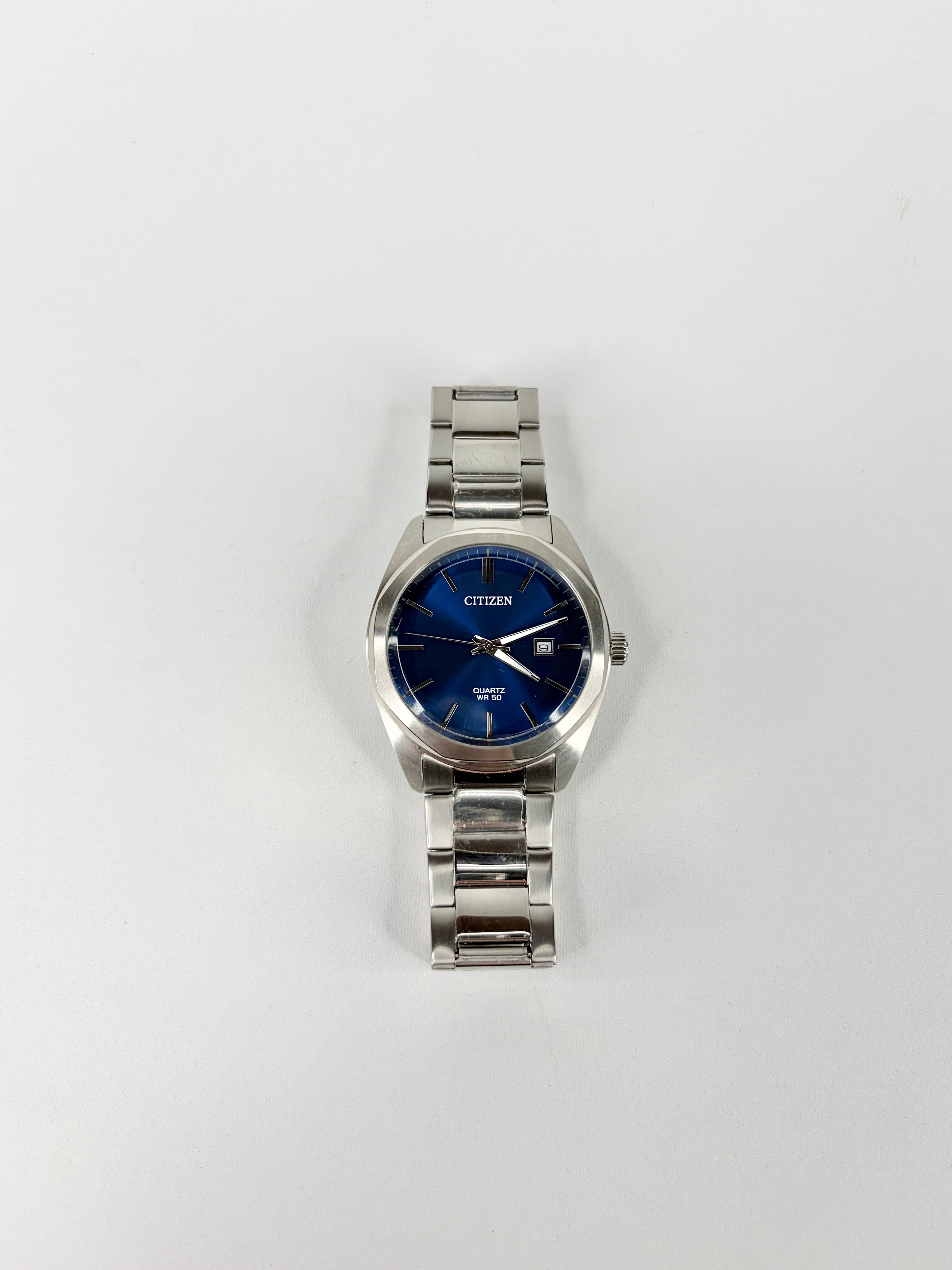 Silver watch with a blue face on a white background