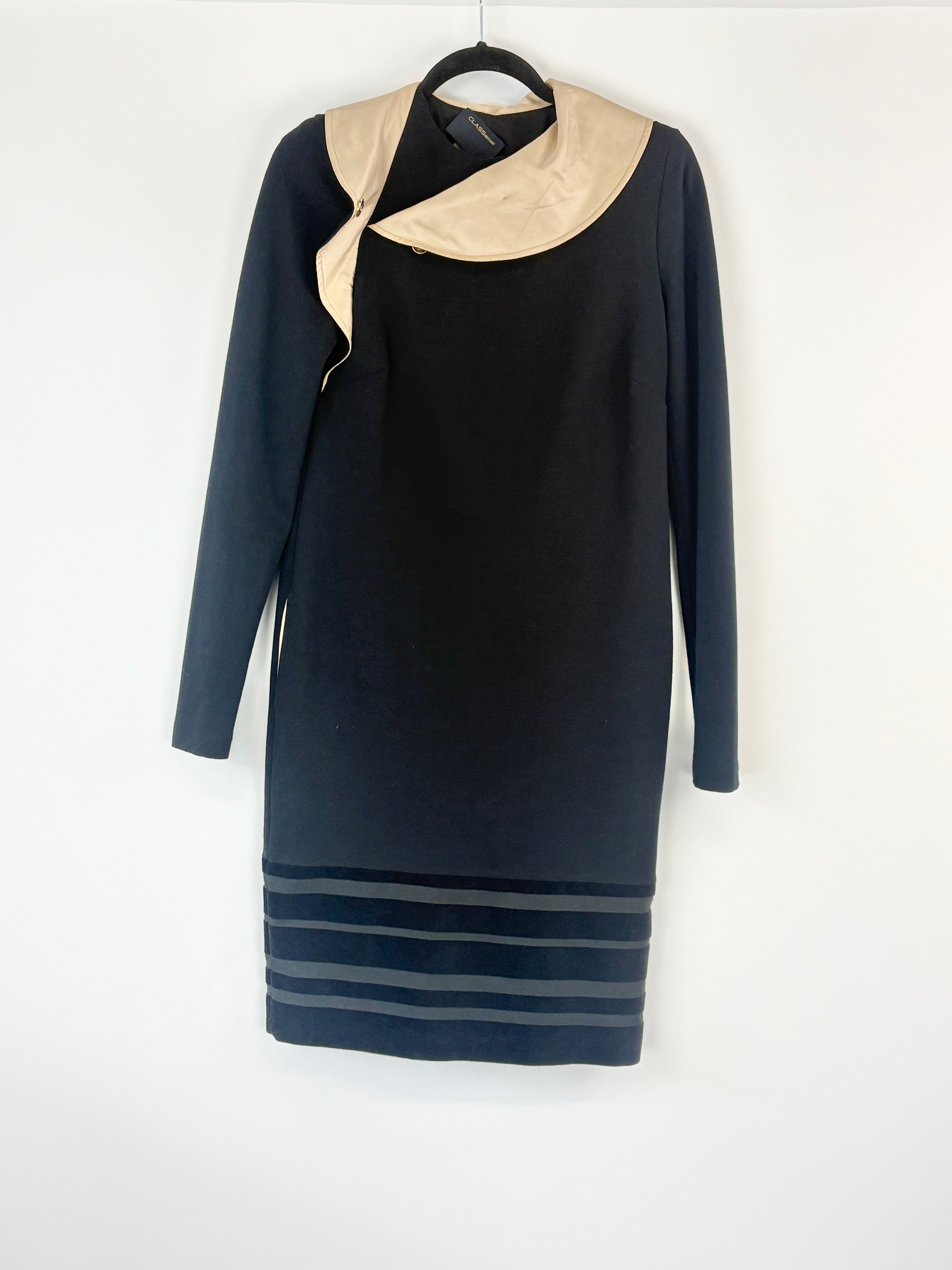 Black dress with beige collar on a hanger against a white background