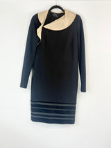 Black dress with beige collar on a hanger against a white background