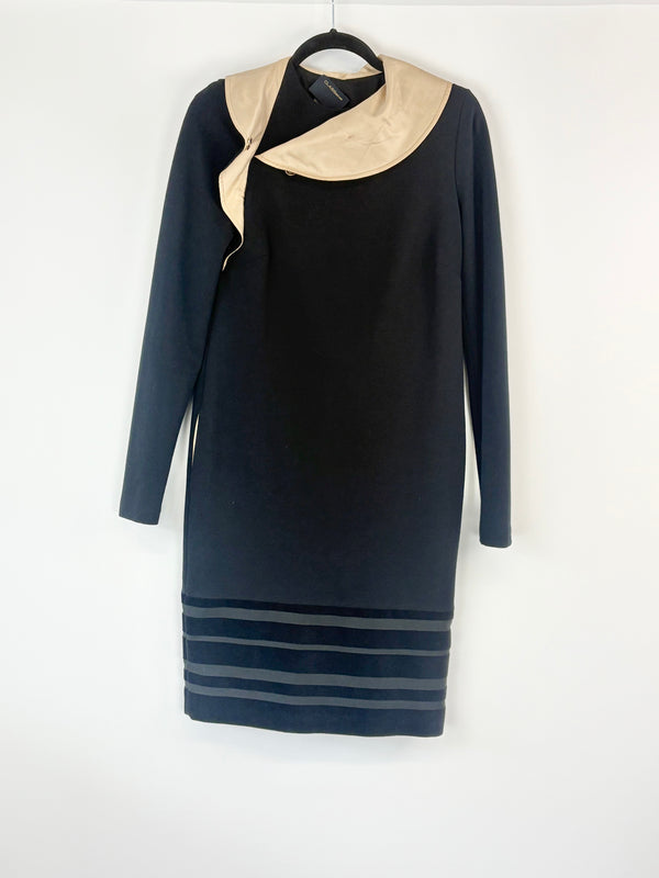 Black dress with beige collar on a hanger against a white background