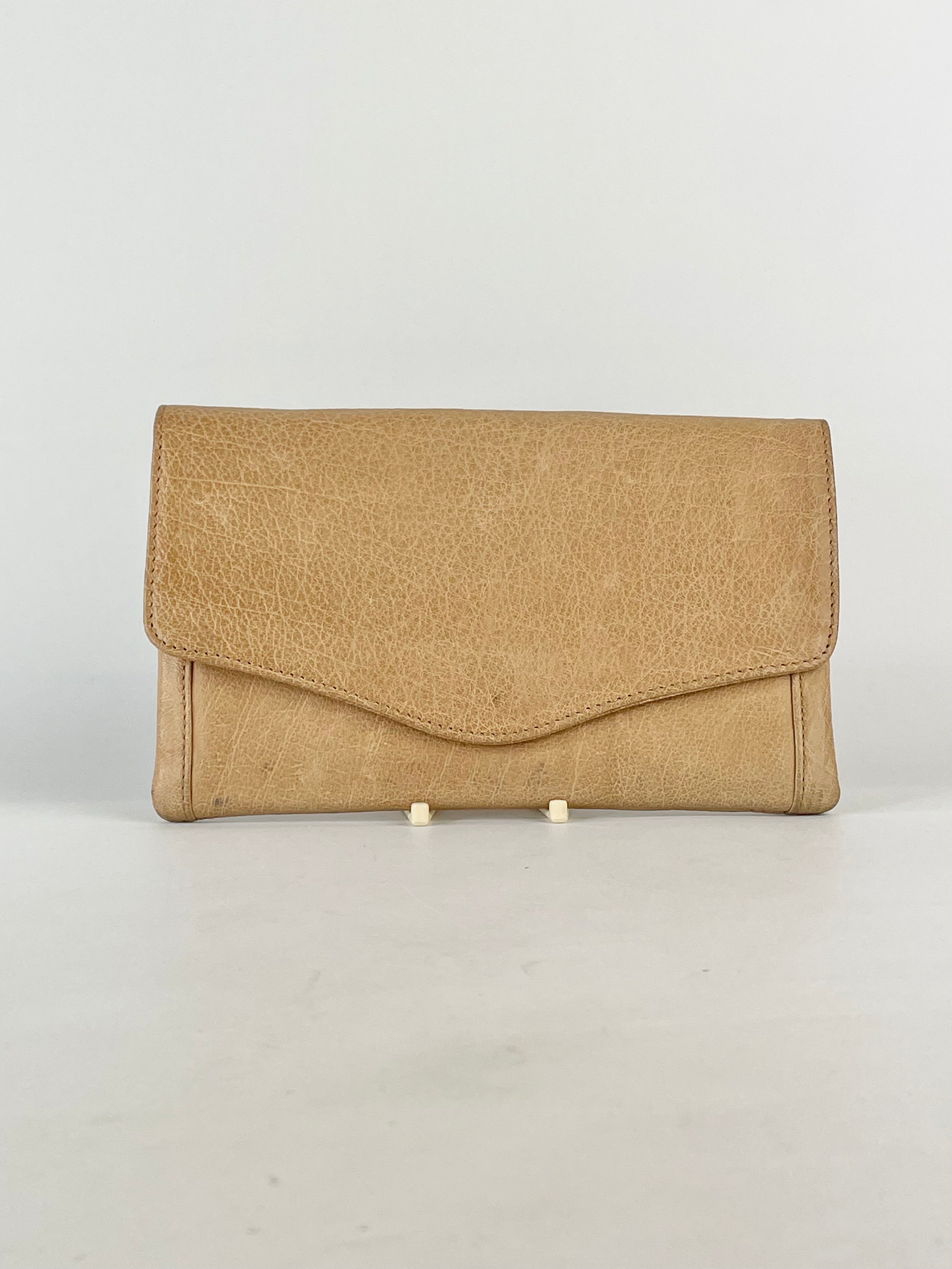 A beige leather envelope wallet with a simple design and a zipper closure.