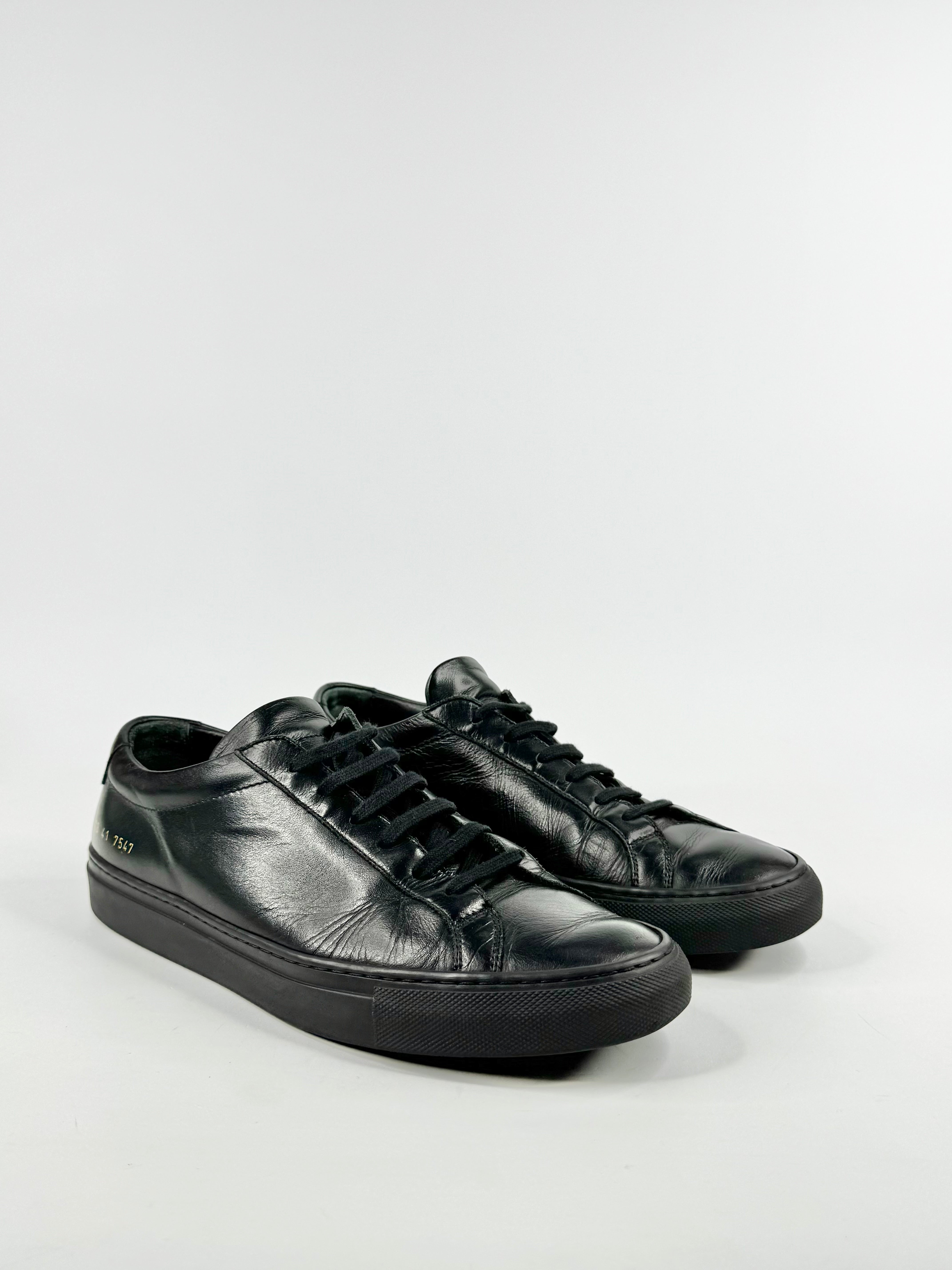 Pair of black leather sneakers on a white background