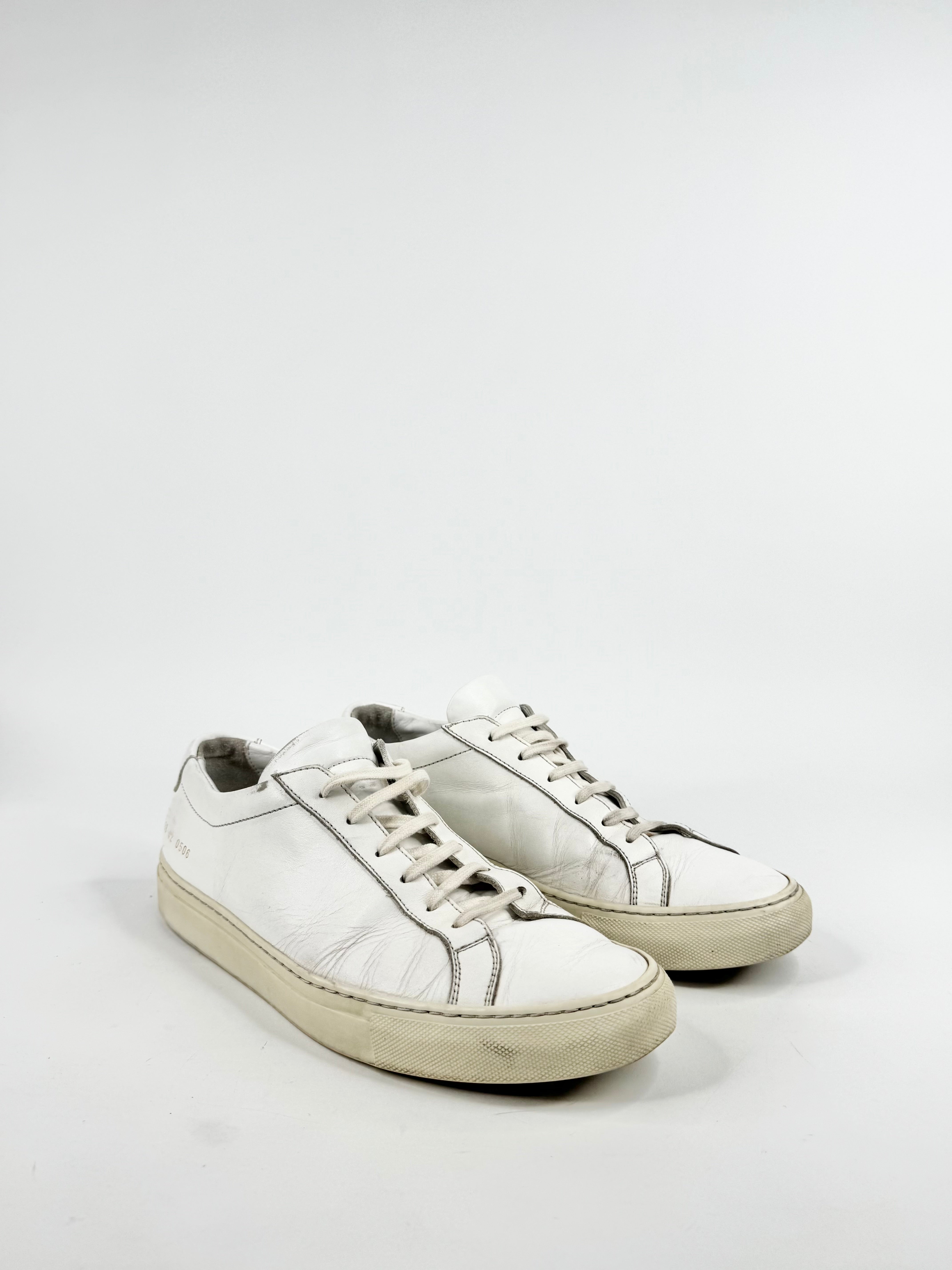 Pair of white sneakers on a light gray background