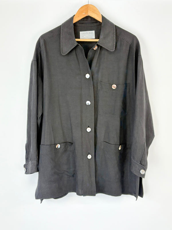 Black Country Road coat with button details on a wooden hanger against a white background
