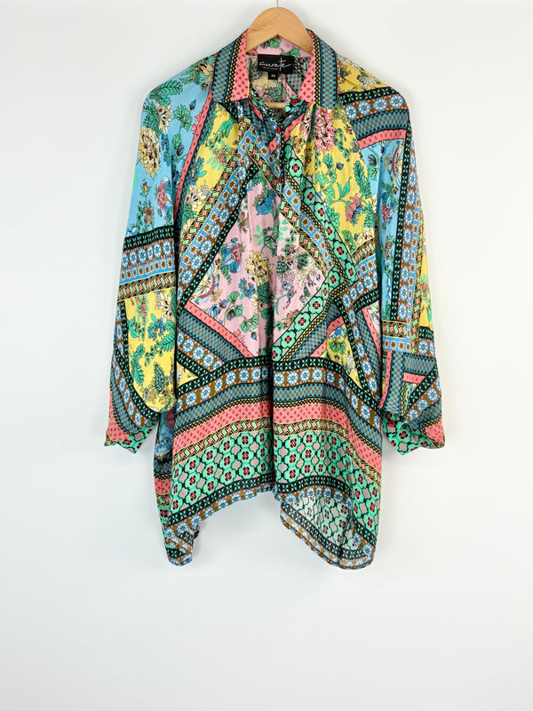 Colorful patterned shirt on a hanger against a white background